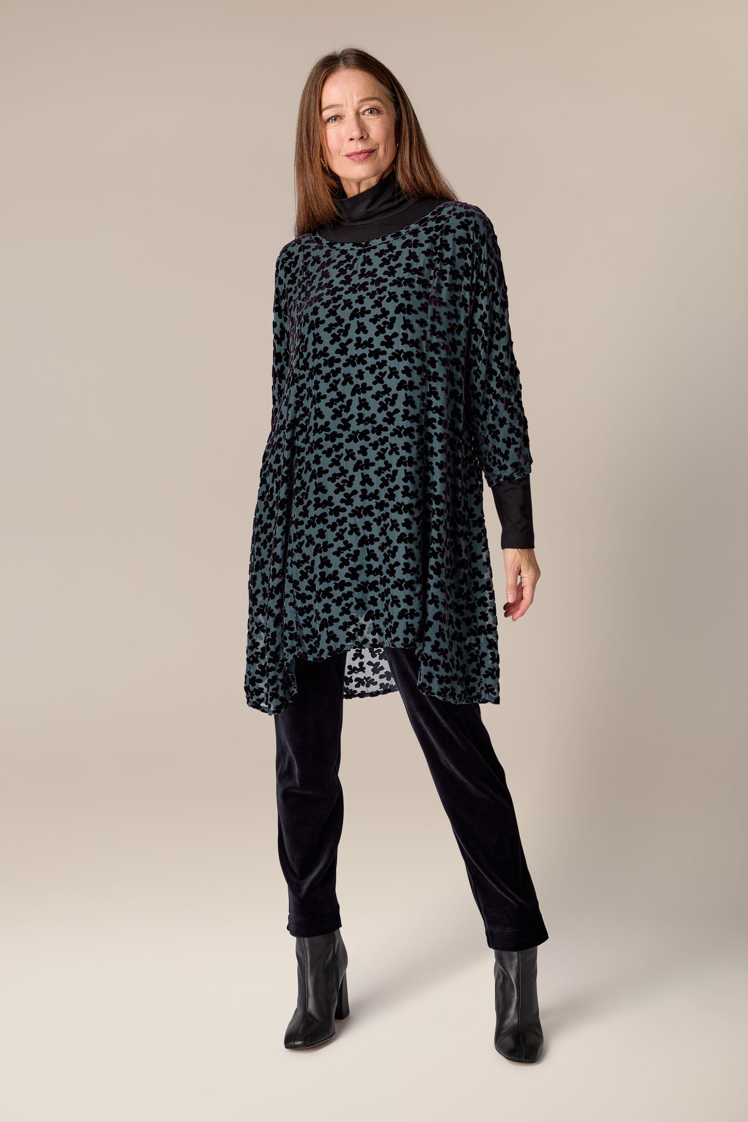 A woman adorned in a Devore Tunic, showcasing the luxurious burned-out velvet textile.