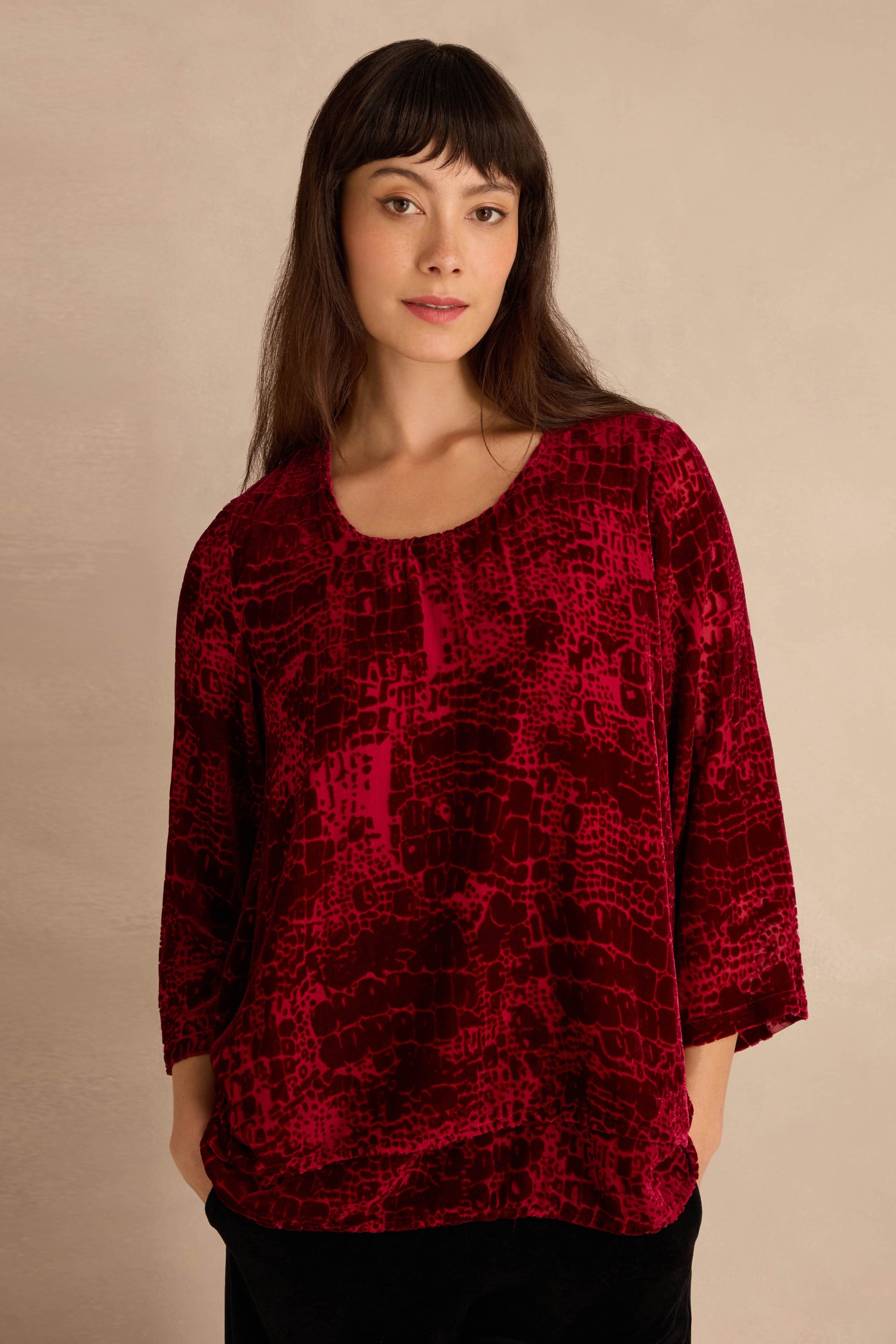 Woman wearing the Ruby Leopard Devore Layered Top, standing against a neutral background with her hands in her pockets.