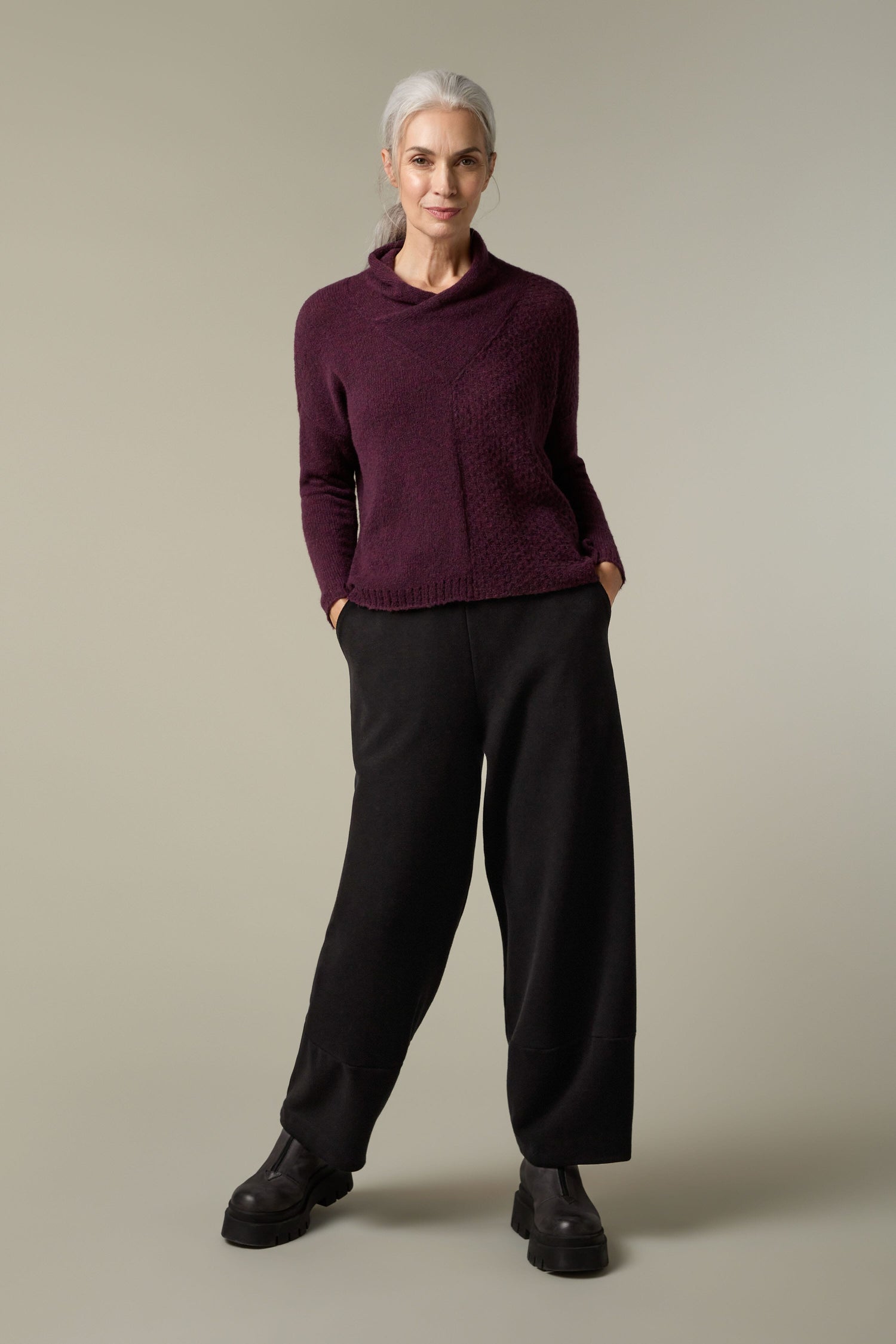 A woman wearing a Grizas Panel Knit, showcasing cosy layering with a plush knit.