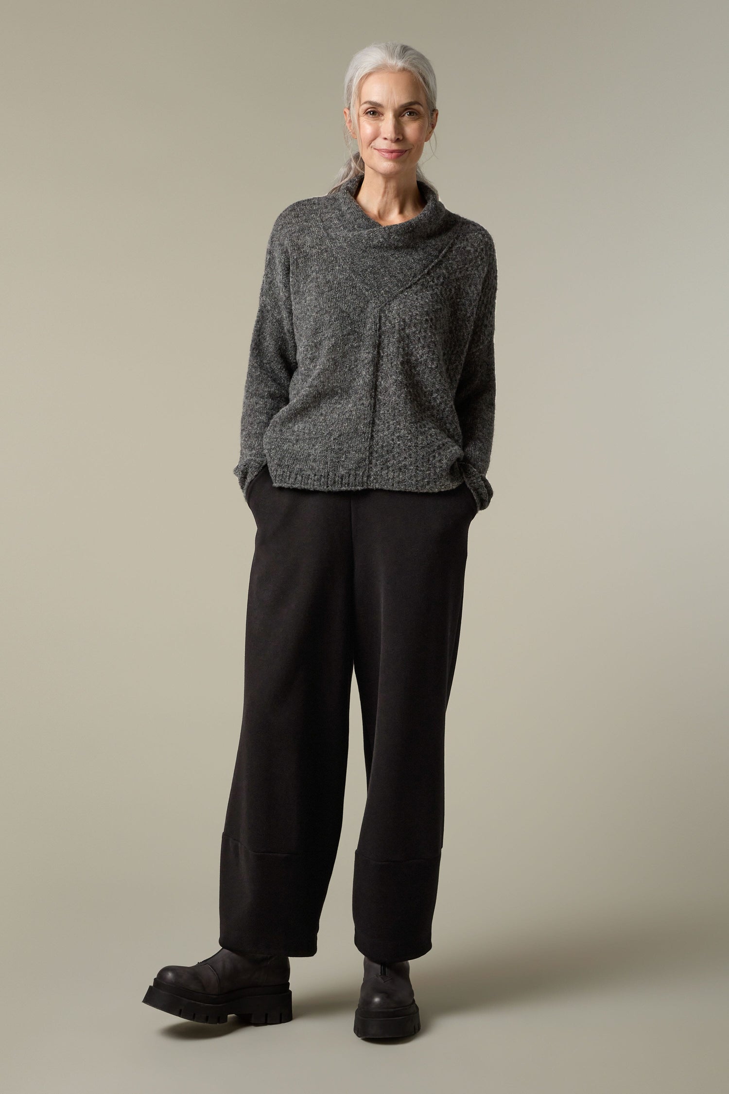 A woman wearing a black Panel Knit sweater.