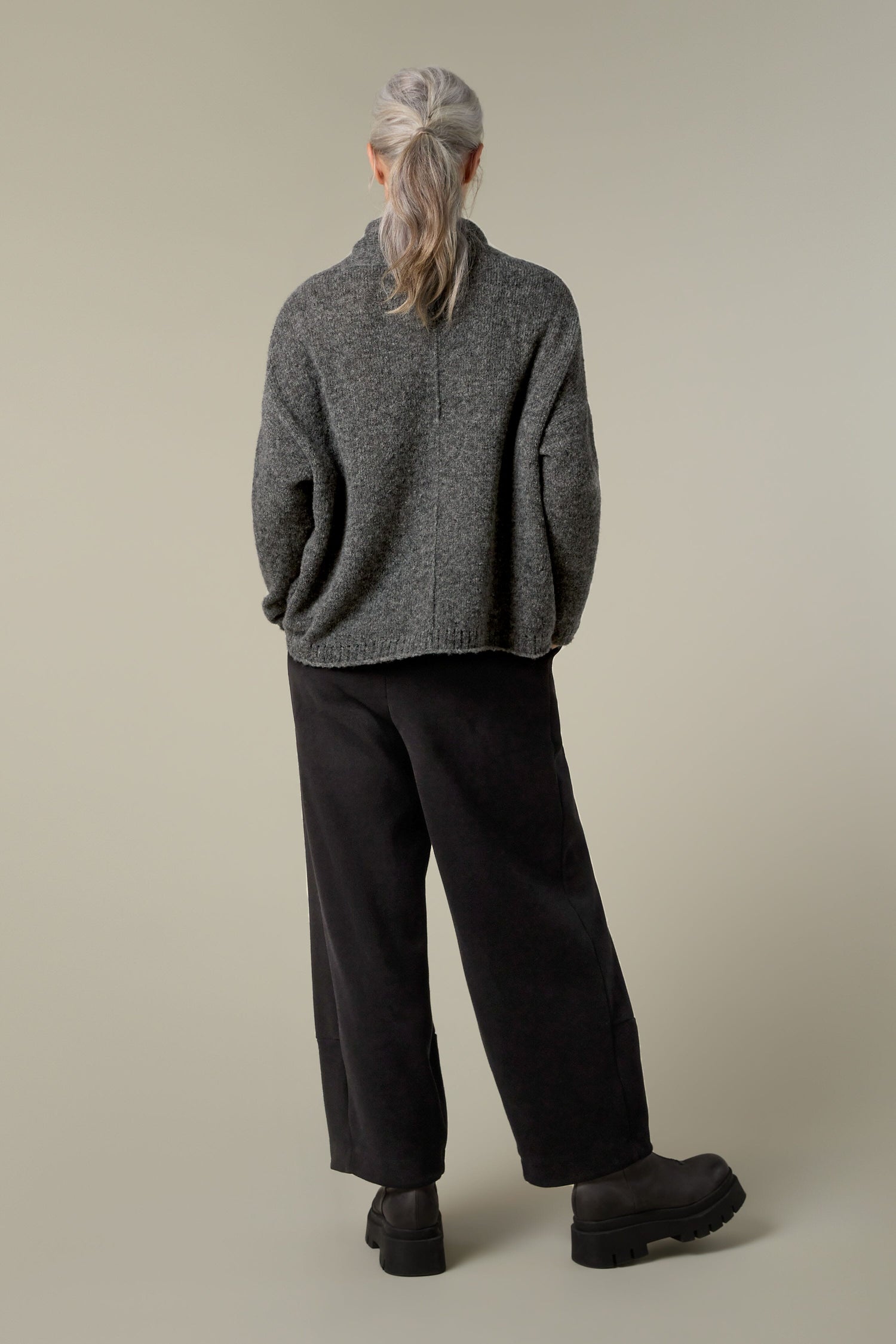 The back view of a woman wearing a cosy Panel Knit sweater.