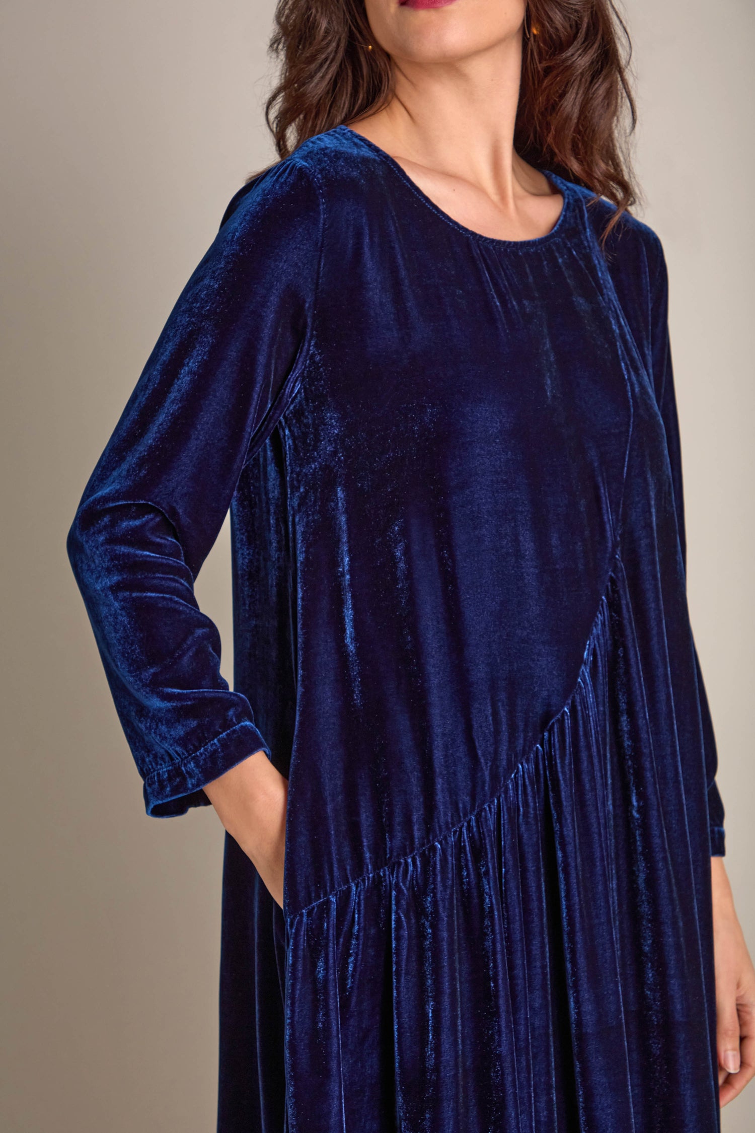 A person models the Drape Front Silk Velvet Dress in a dark blue hue, featuring long sleeves and a gathered waist detail, epitomizing luxury elegance.