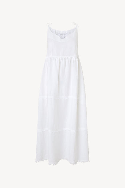 A lightweight Linen Tiered Dress in a white slip-on style, complete with adjustable shoulder ties.