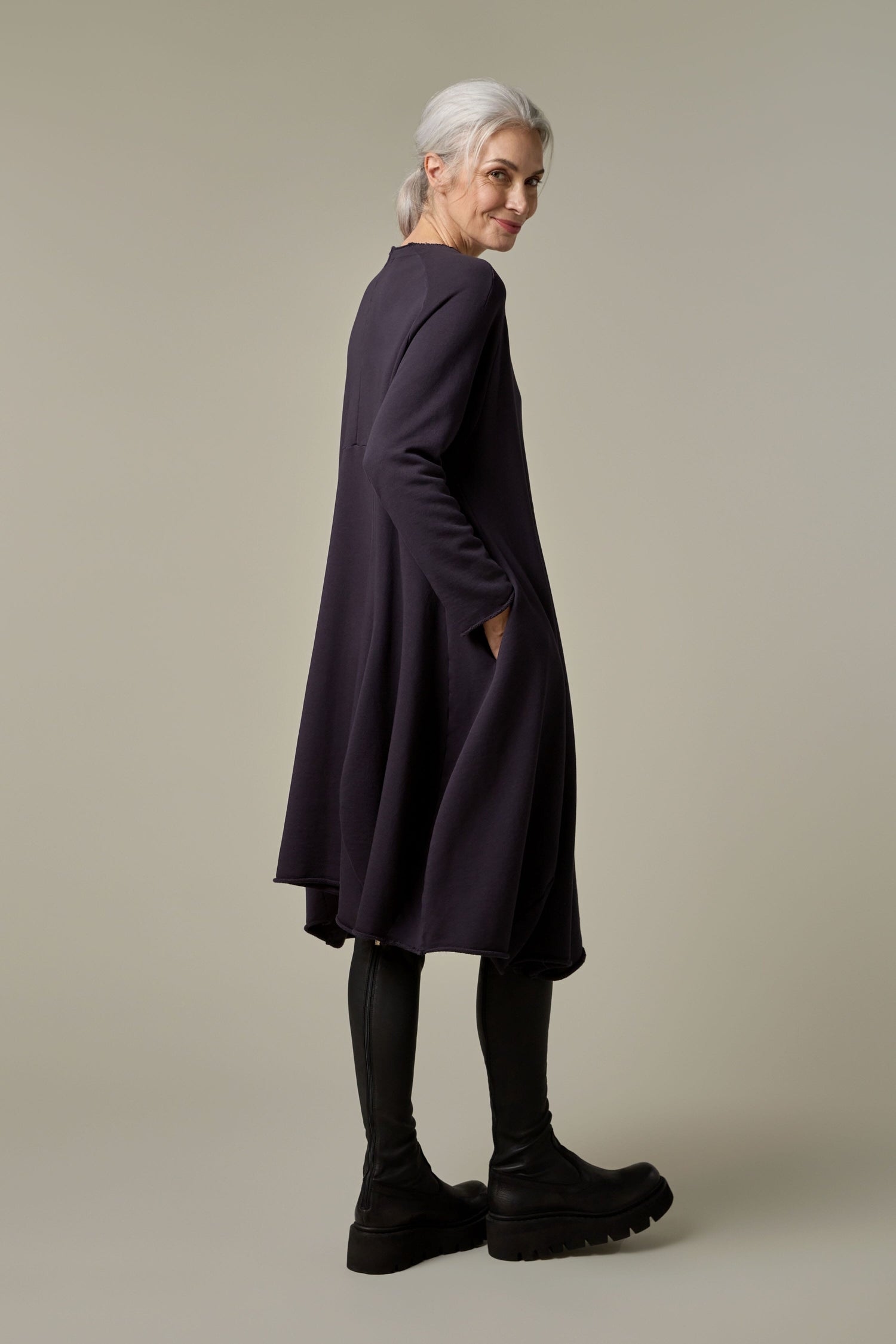 The back view of an older woman wearing a Godet Jersey Dress and black leggings.