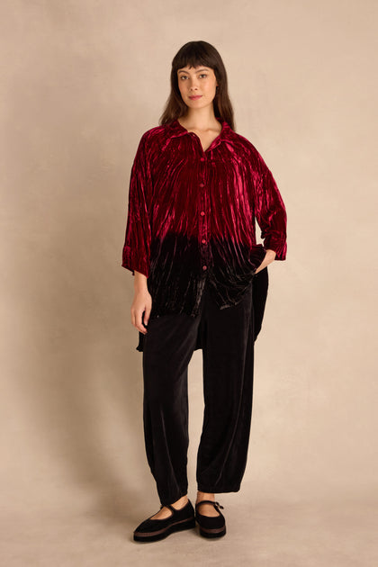 Woman standing against a neutral background, wearing the Ruby Silk Velvet Ombre Shirt, black velvet pants, and black flat shoes.
