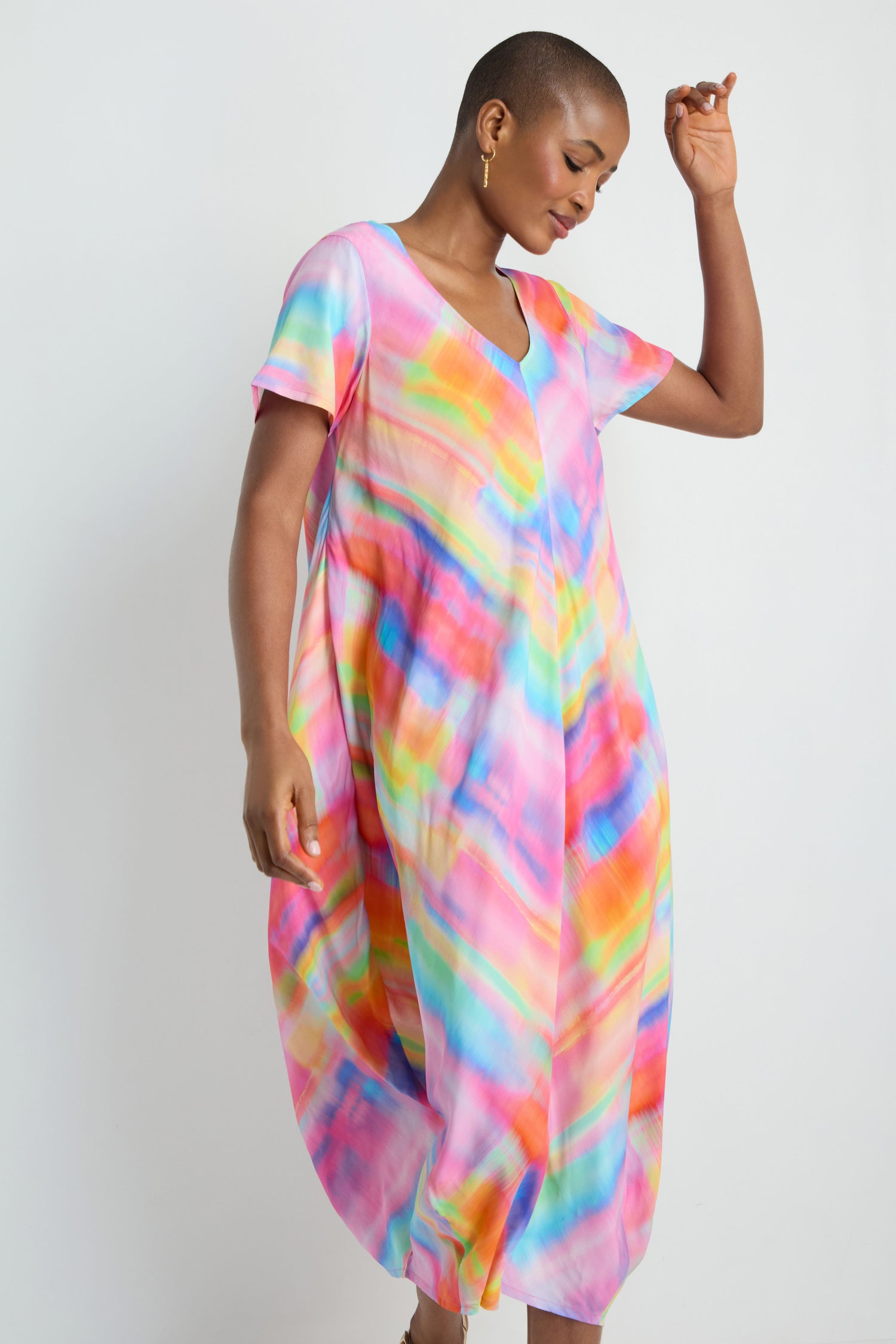 Model wears the Painted Horizon Bubble Dress, a loose-fitting tie-dye design with short sleeves, shown against a plain white background.