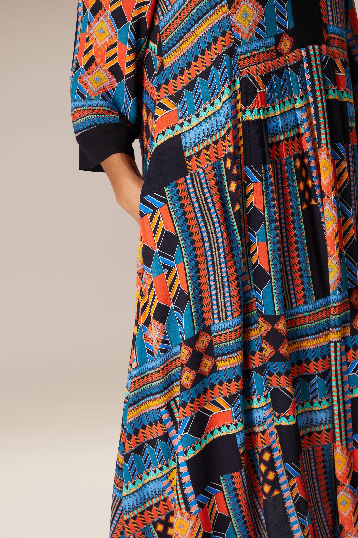 A woman is wearing a Bold Graphic Printed Dress with bohemian elegance.