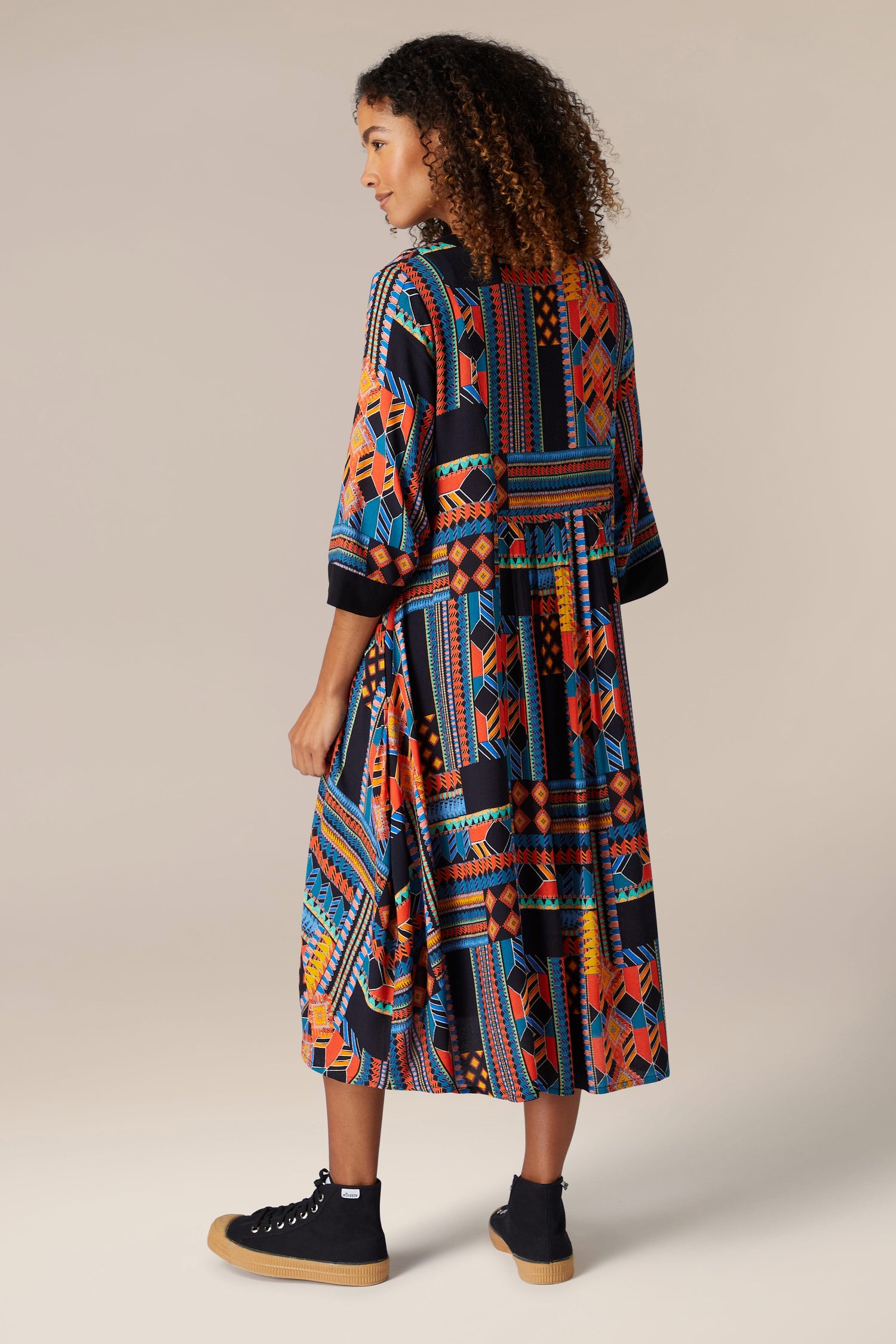 The back view of a woman wearing a Bold Graphic Printed Dress.