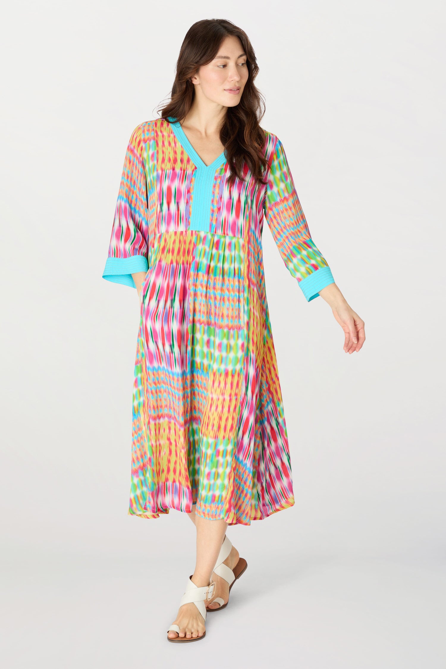 A woman wearing a Kaleidoscope Ikat Flare Dress with an embroidered turquoise neckline.