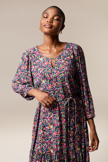 A chic woman wearing a Miniature Floral Garden Dress.