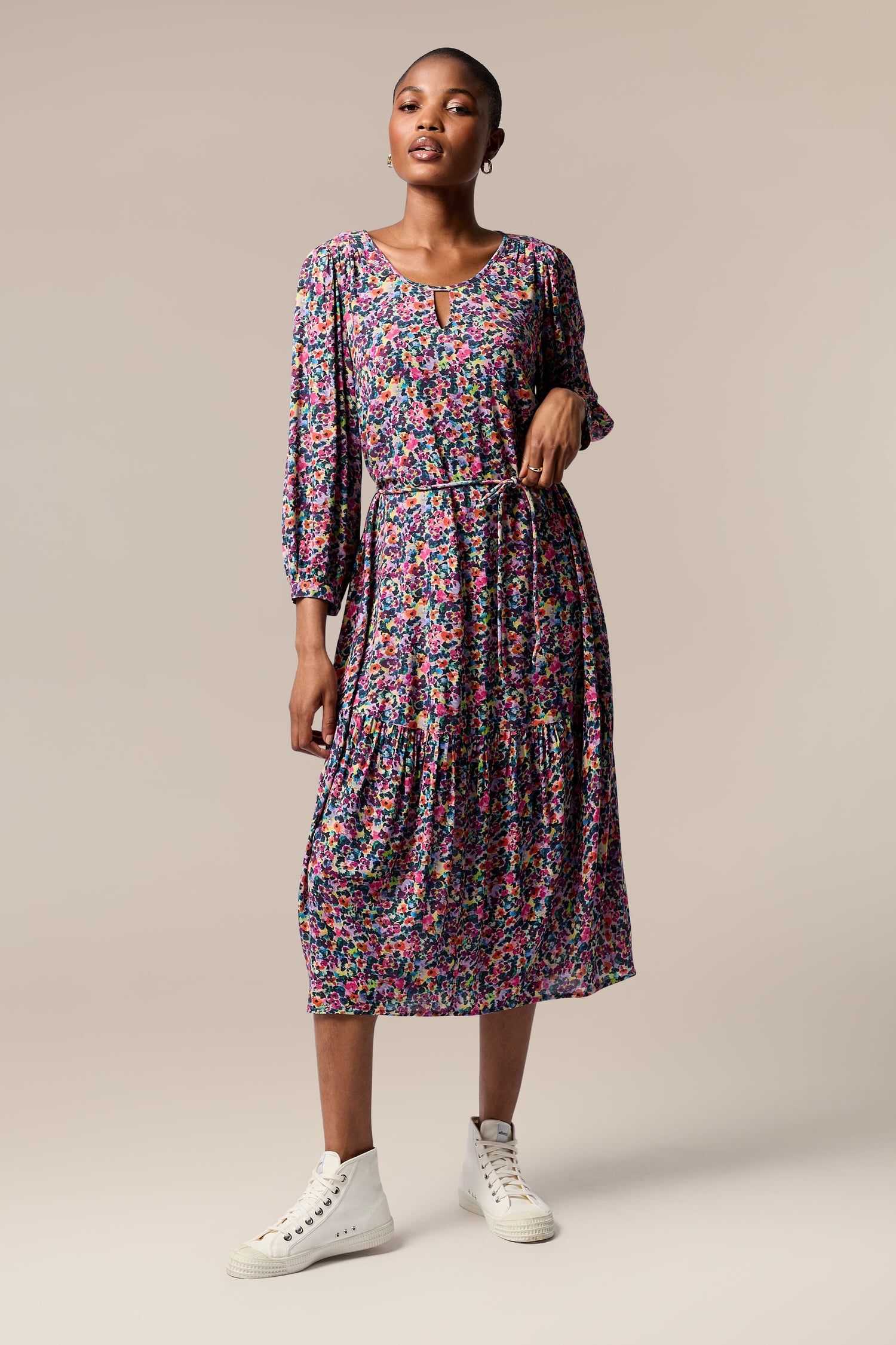 The sustainable model is wearing a chic Miniature Floral Garden Dress.