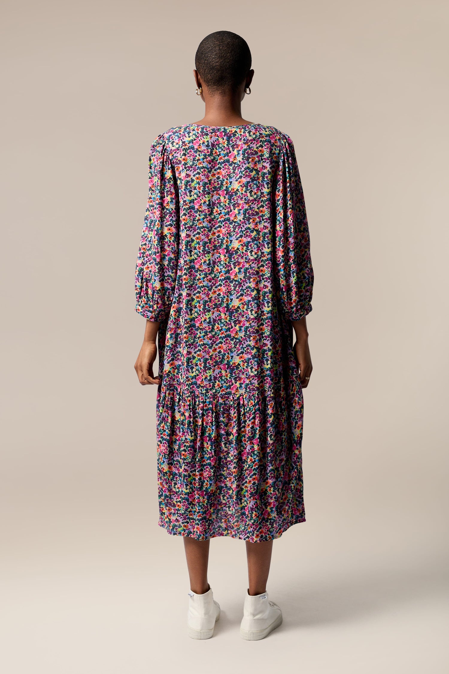 The back view of a sustainable woman wearing a Miniature Floral Garden Dress.