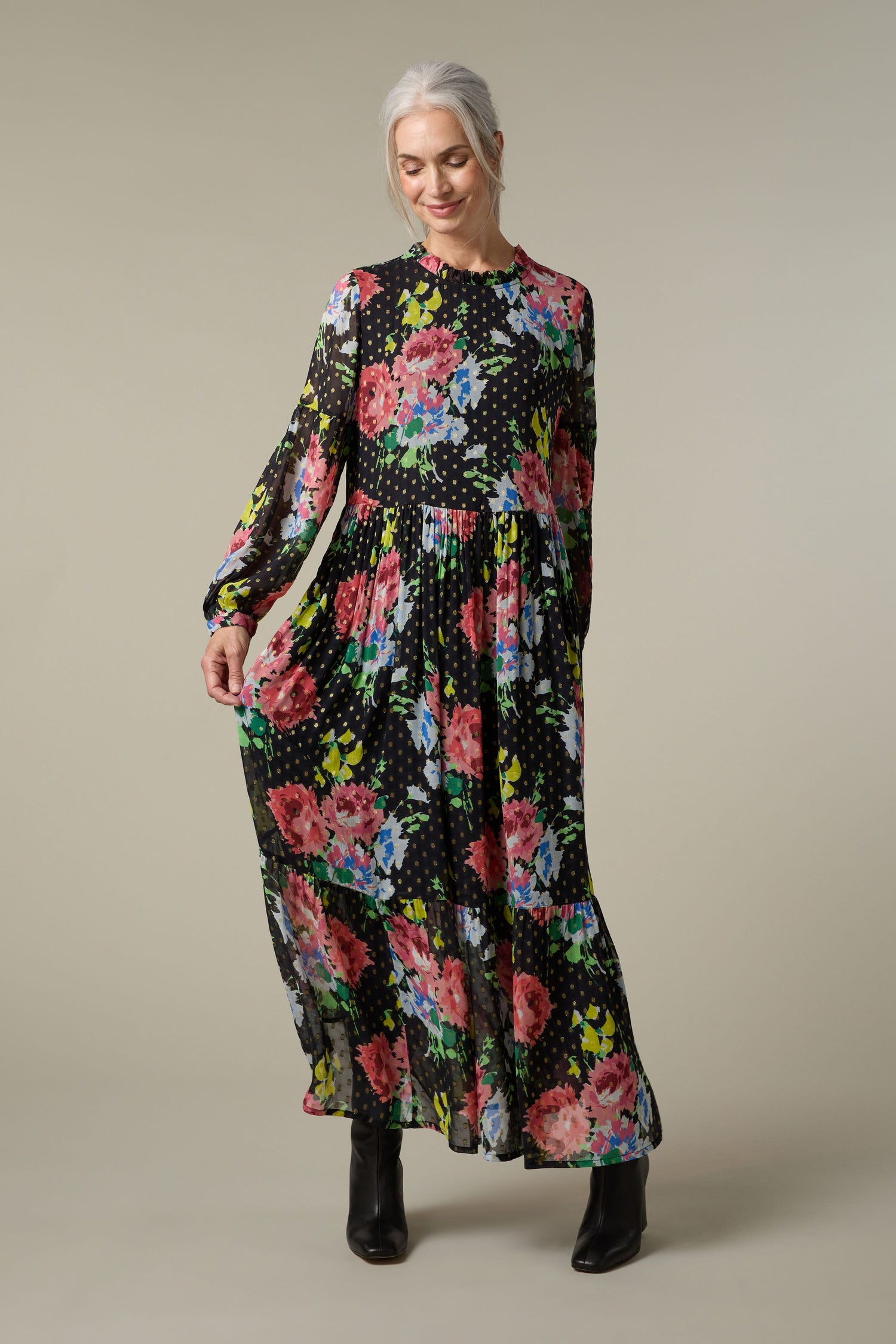 A woman wearing a Floral Bouquet Maxi Dress, featuring a print of flowers and polka dots.