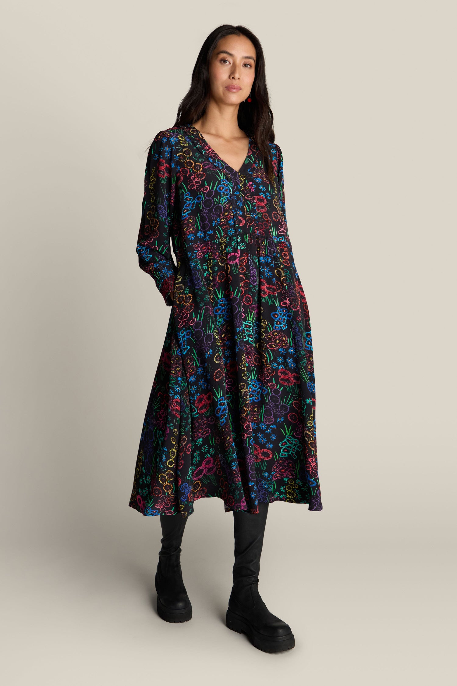 A person wearing the Embroidered Floral Print Dress with colorful patterns and black boots stands against a plain background.