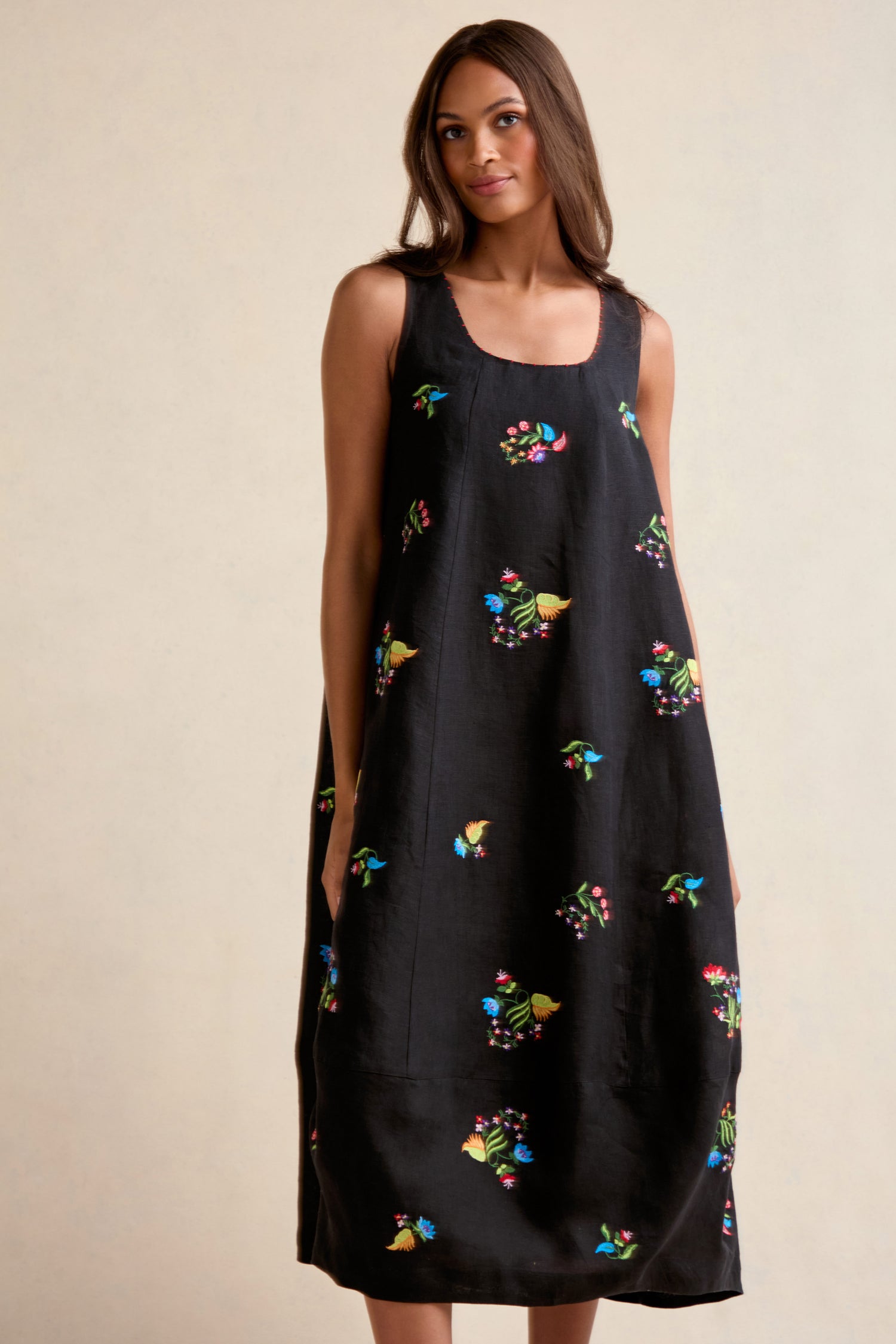 A woman models the Vintage Floral Embroidered Bubble Dress, featuring vibrant floral embroidery and a relaxed lantern silhouette, set against a simple light backdrop.