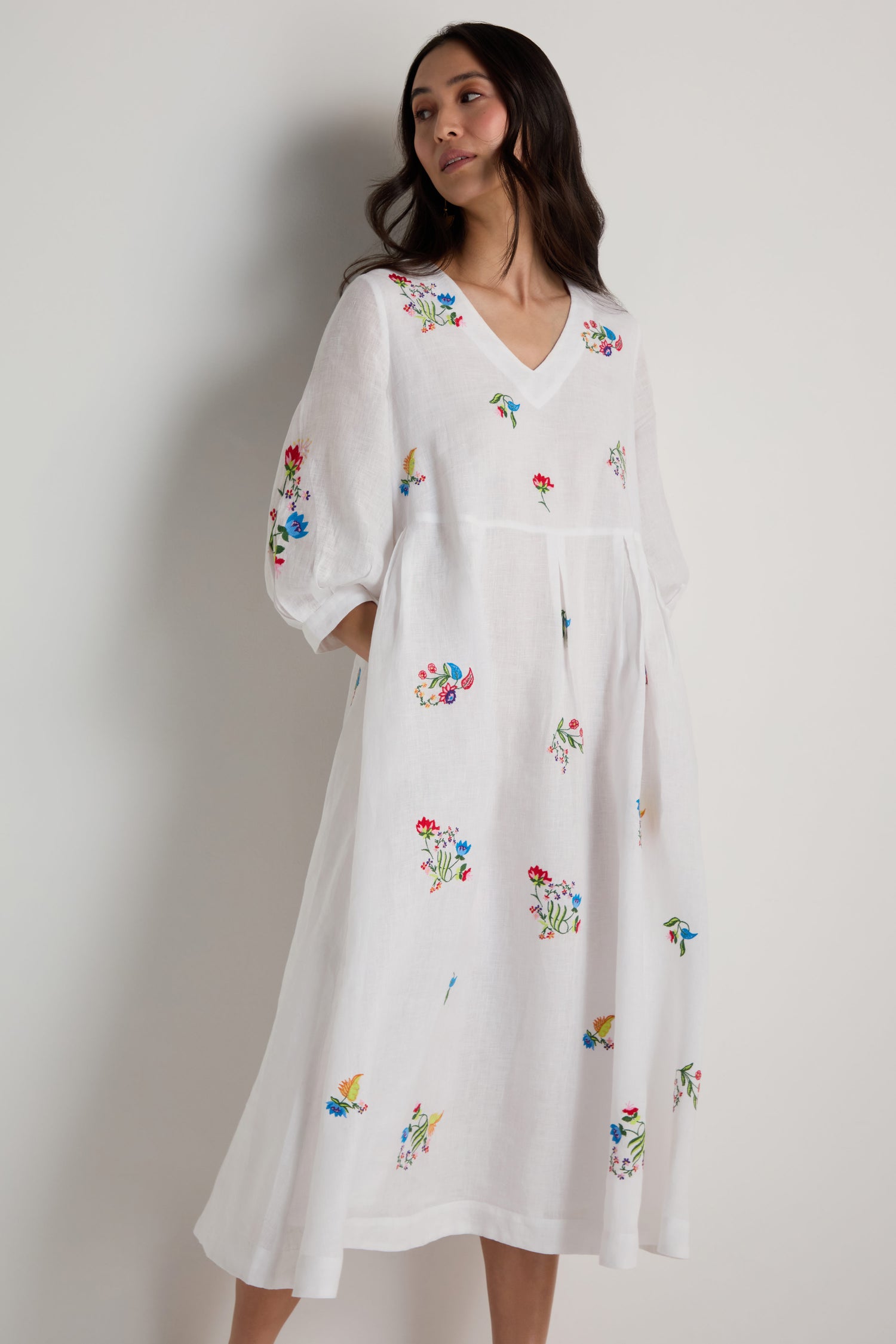 A woman models the Vintage Floral Embroidered Flare Dress, featuring colorful embroidery, a V-neckline, and loose three-quarter sleeves—ideal for summer with its midi length and vintage-inspired style.
