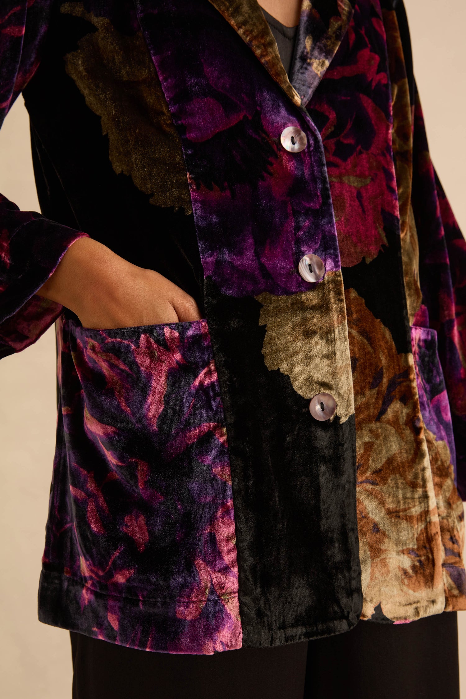 Midnight Peonies Velvet Relaxed Blazer in a relaxed-fit with a large-scale purple and brown floral print, three front buttons, and a visible hand in a patch pocket.