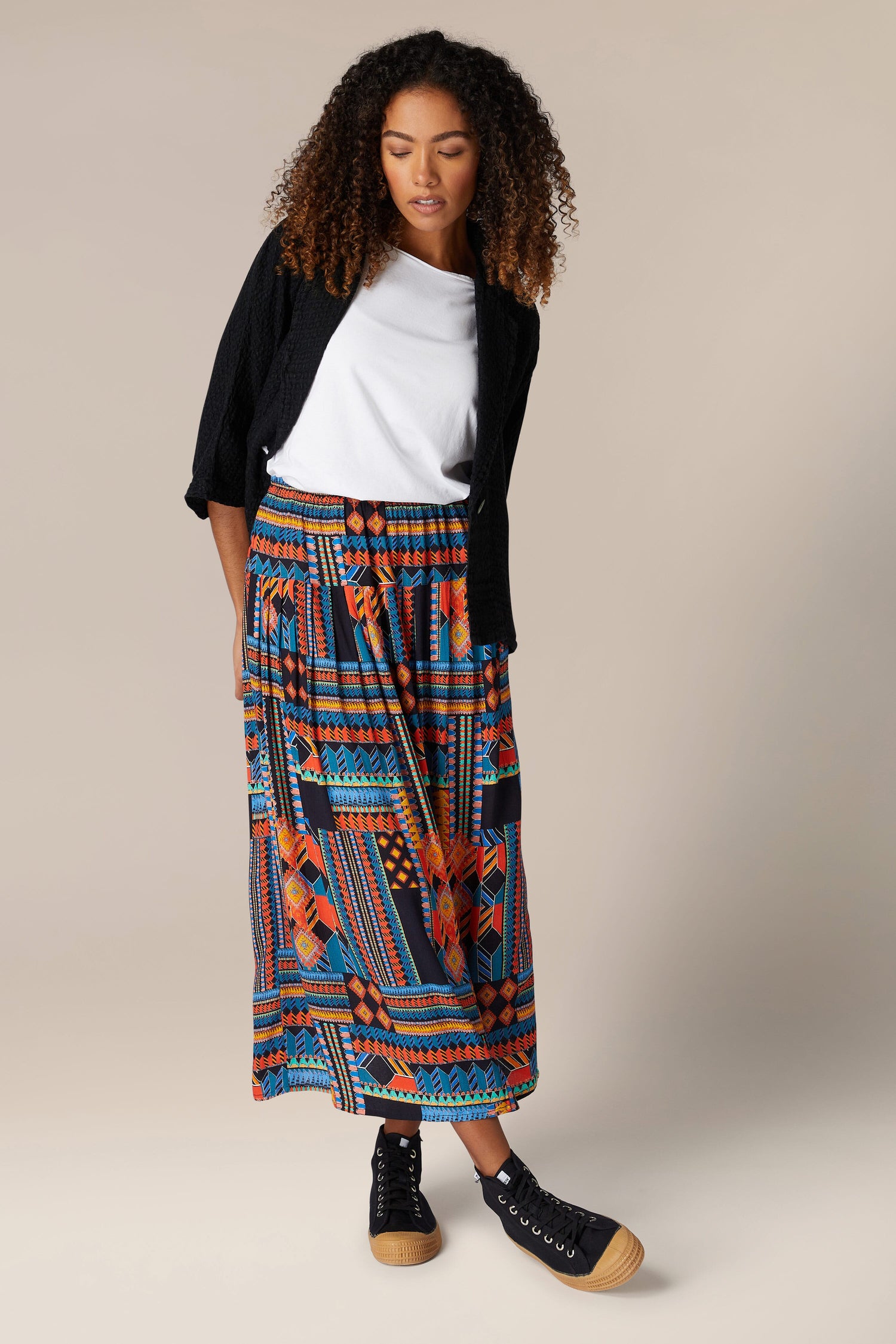 A woman wearing a vibrant Bold Graphic Printed Skirt with flowing midi length.
