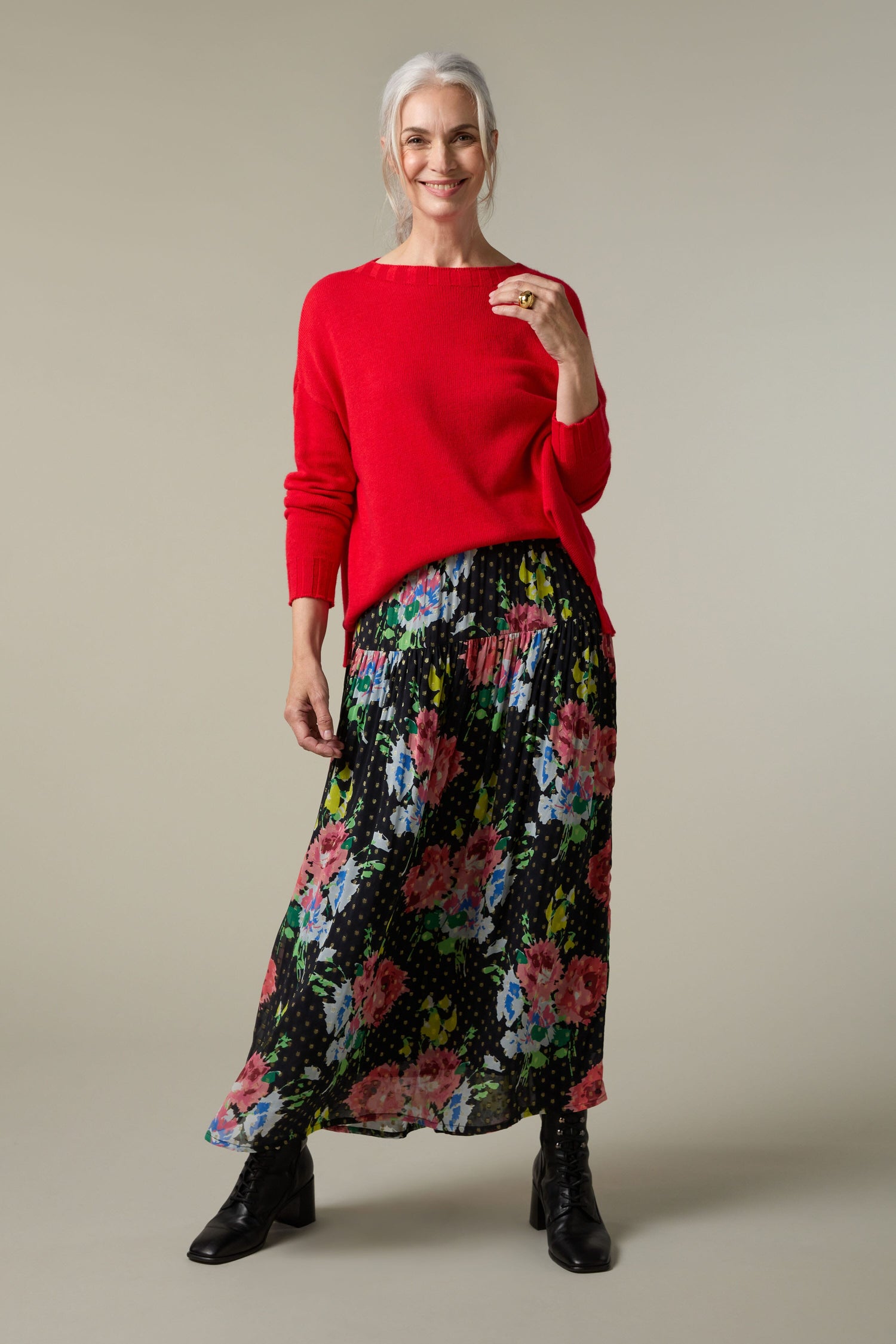 A woman wearing a red sweater and a Vintage Floral Bouquet Skirt.