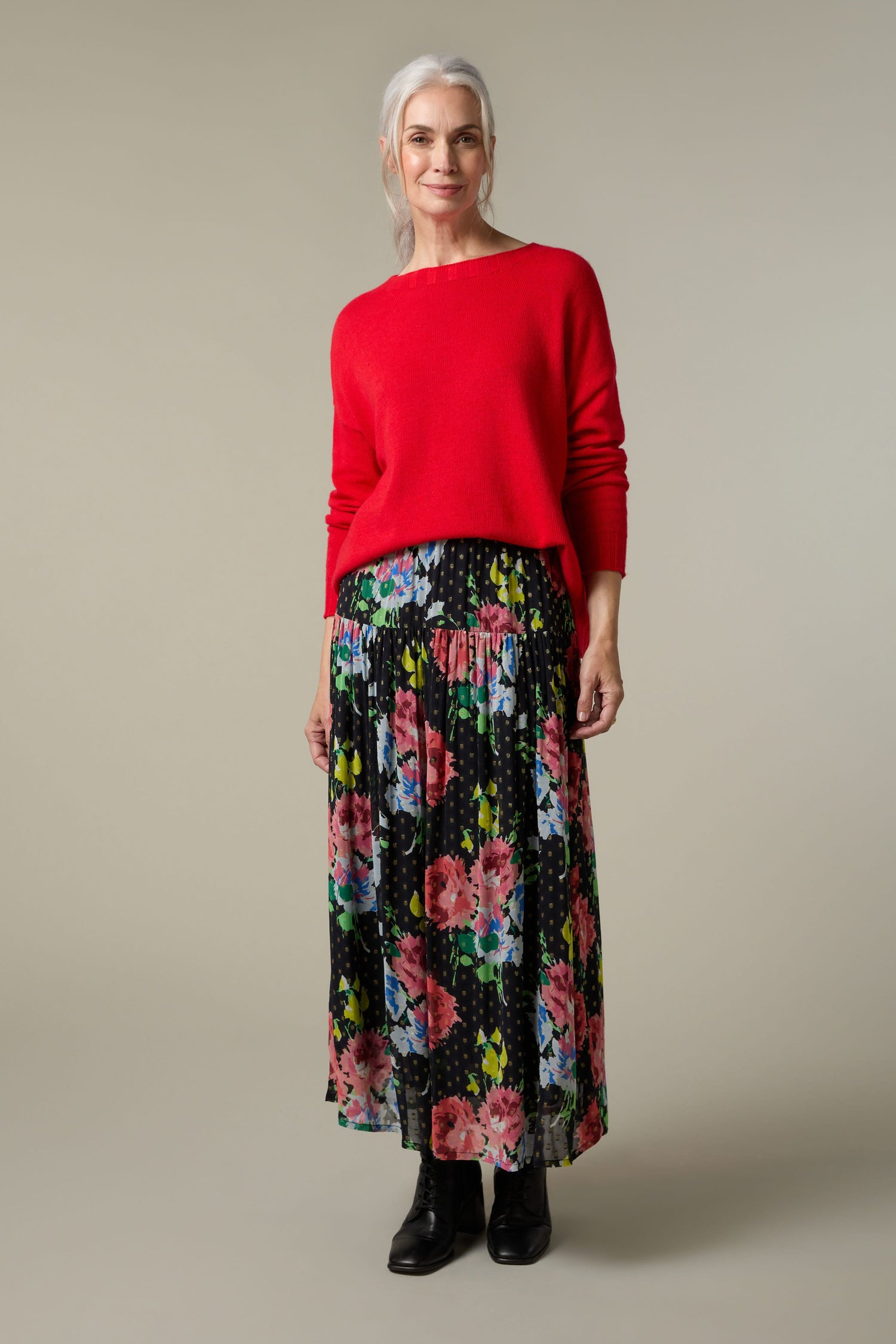 A woman wearing a red sweater and the Vintage Floral Bouquet Skirt, an all-occasion wardrobe addition.