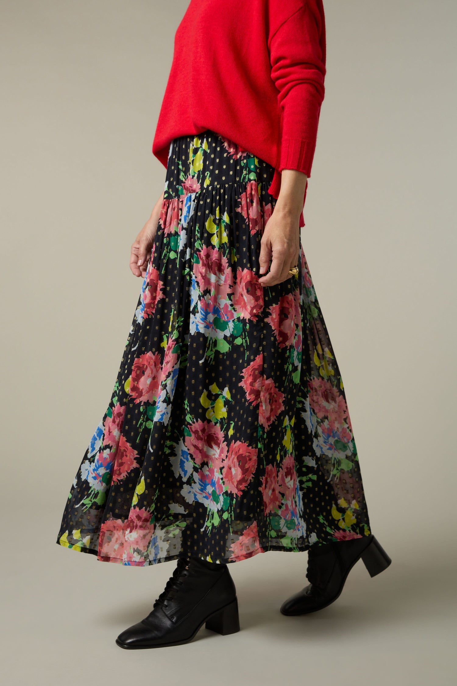 A woman wearing a red sweater and Vintage Floral Bouquet Skirt.