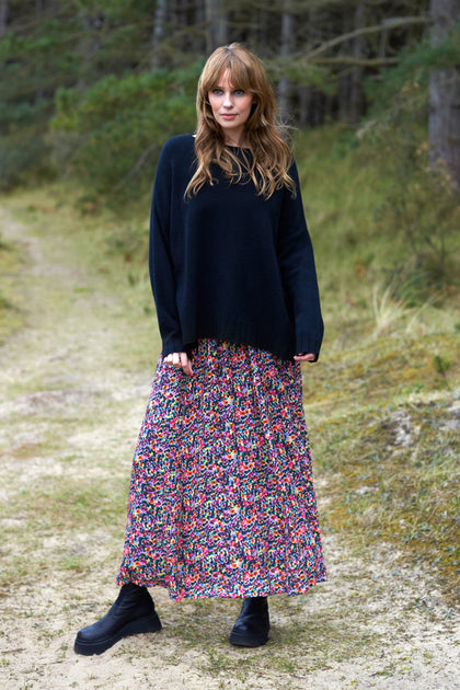 A woman wearing a Miniature Floral Garden Skirt in the woods.