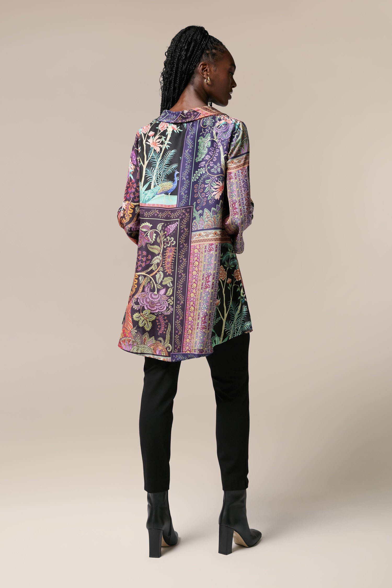 The back view of a woman wearing the Mythical Print Silk Tunic with a colorful bohemian print.