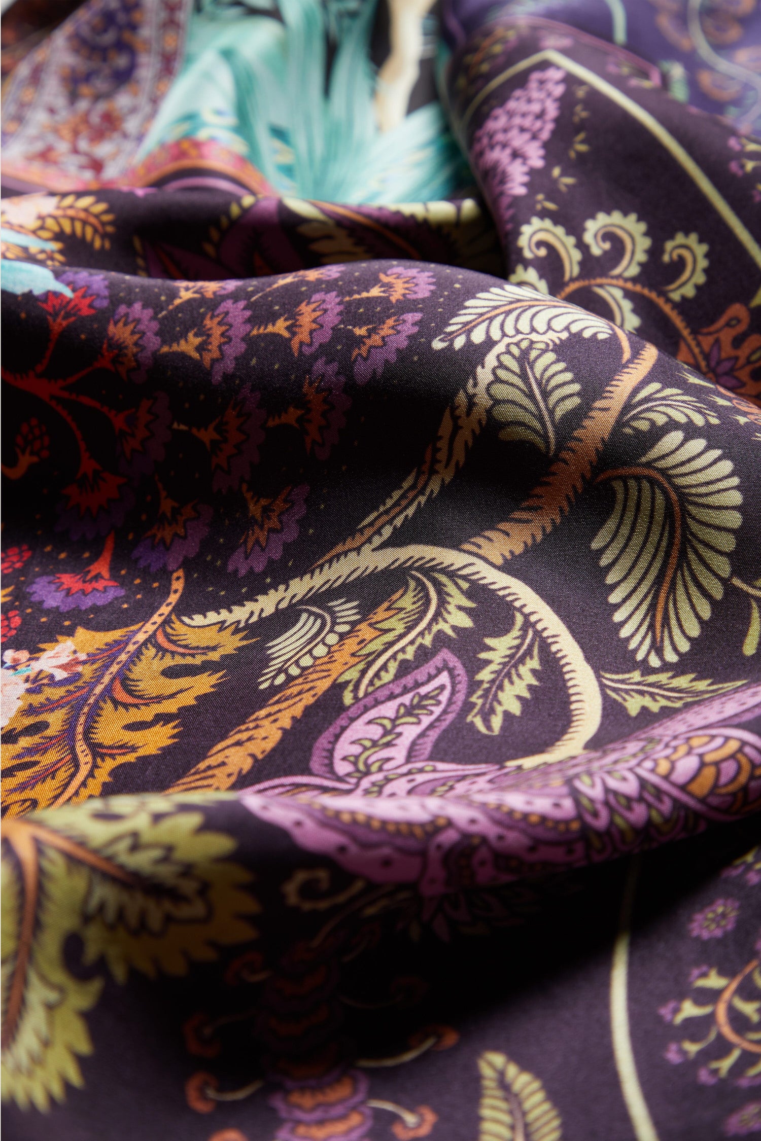 A close up of the Mythical Print Silk Tunic, featuring intricate paisley prints, exuding a bohemian aesthetic.