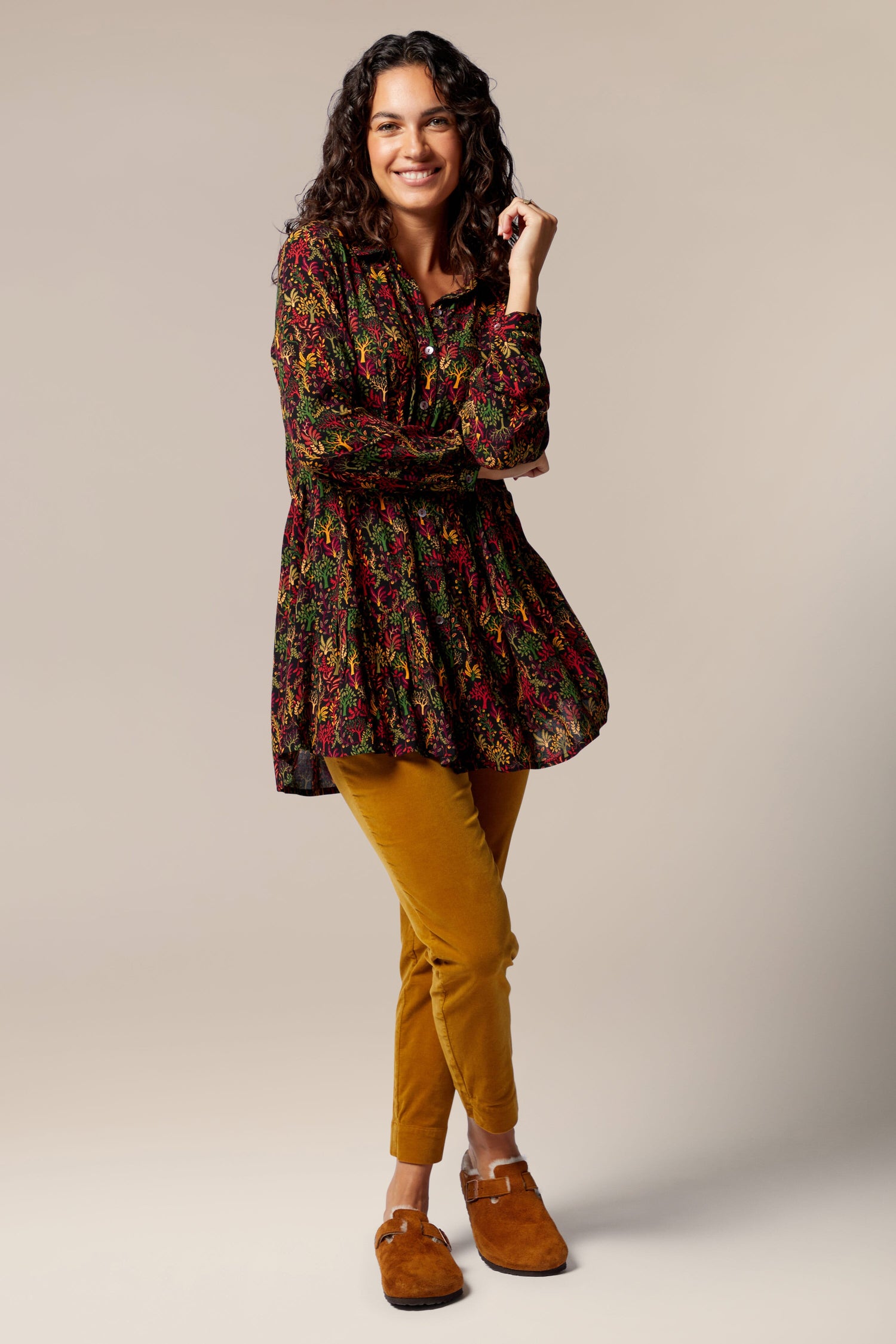 A woman in a Magical Forest Print Shirt and yellow pants, with an autumnal tone, is posing for a photo.