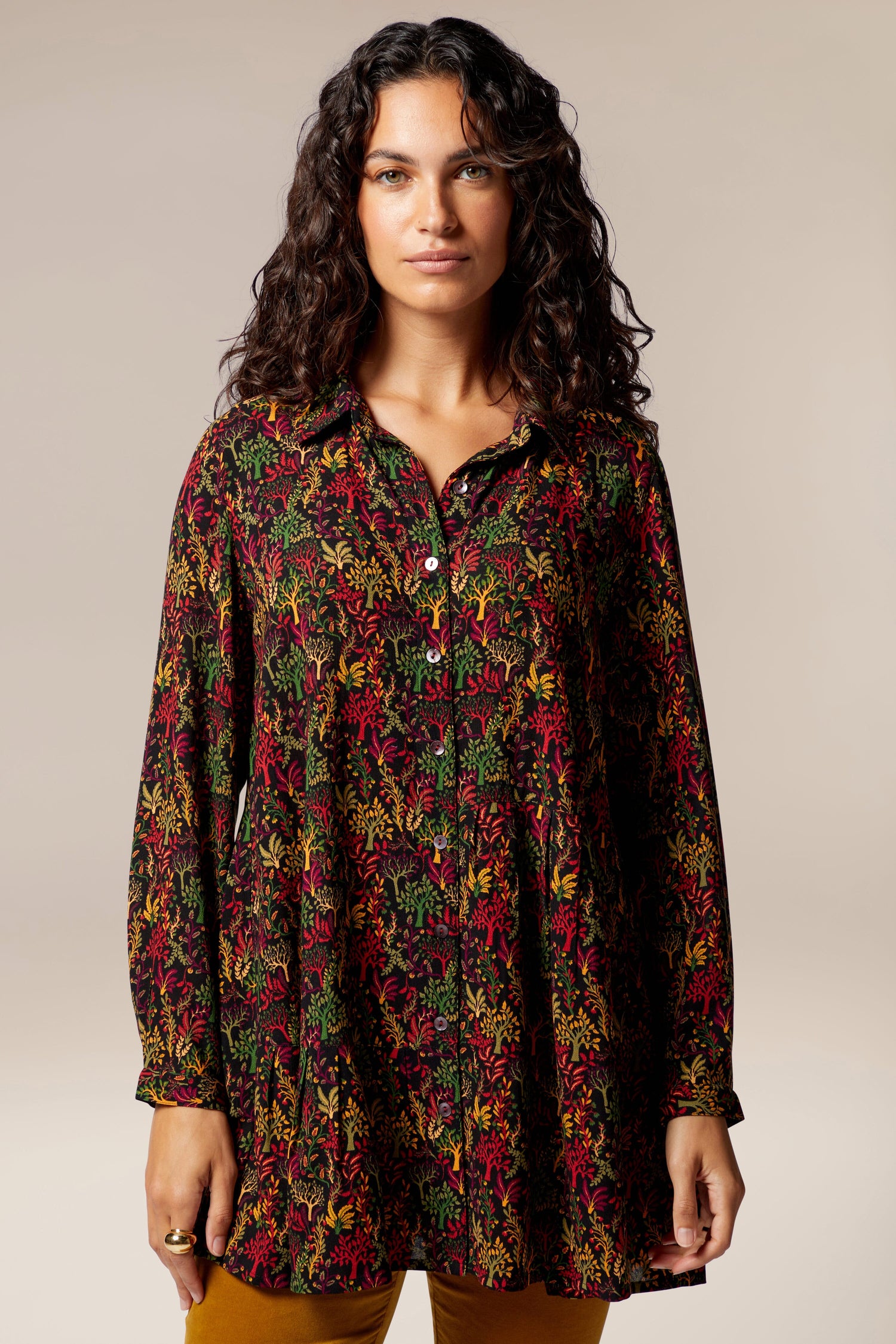 A woman wearing a long-sleeved Magical Forest Print Shirt in autumnal tones.