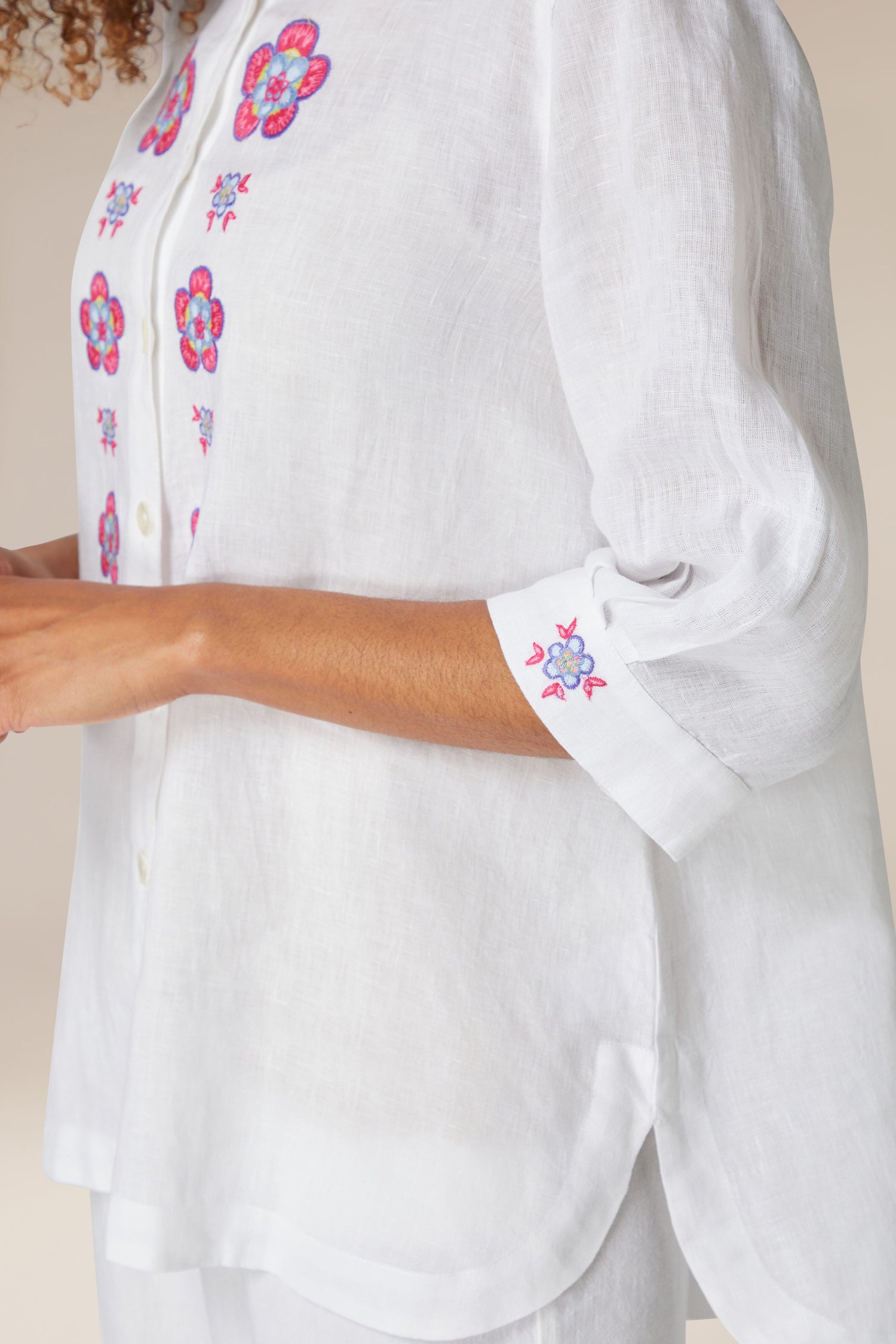 Close-up of a woman in a white pure linen Floral Embroidery Shirt with bracelet-length sleeves.