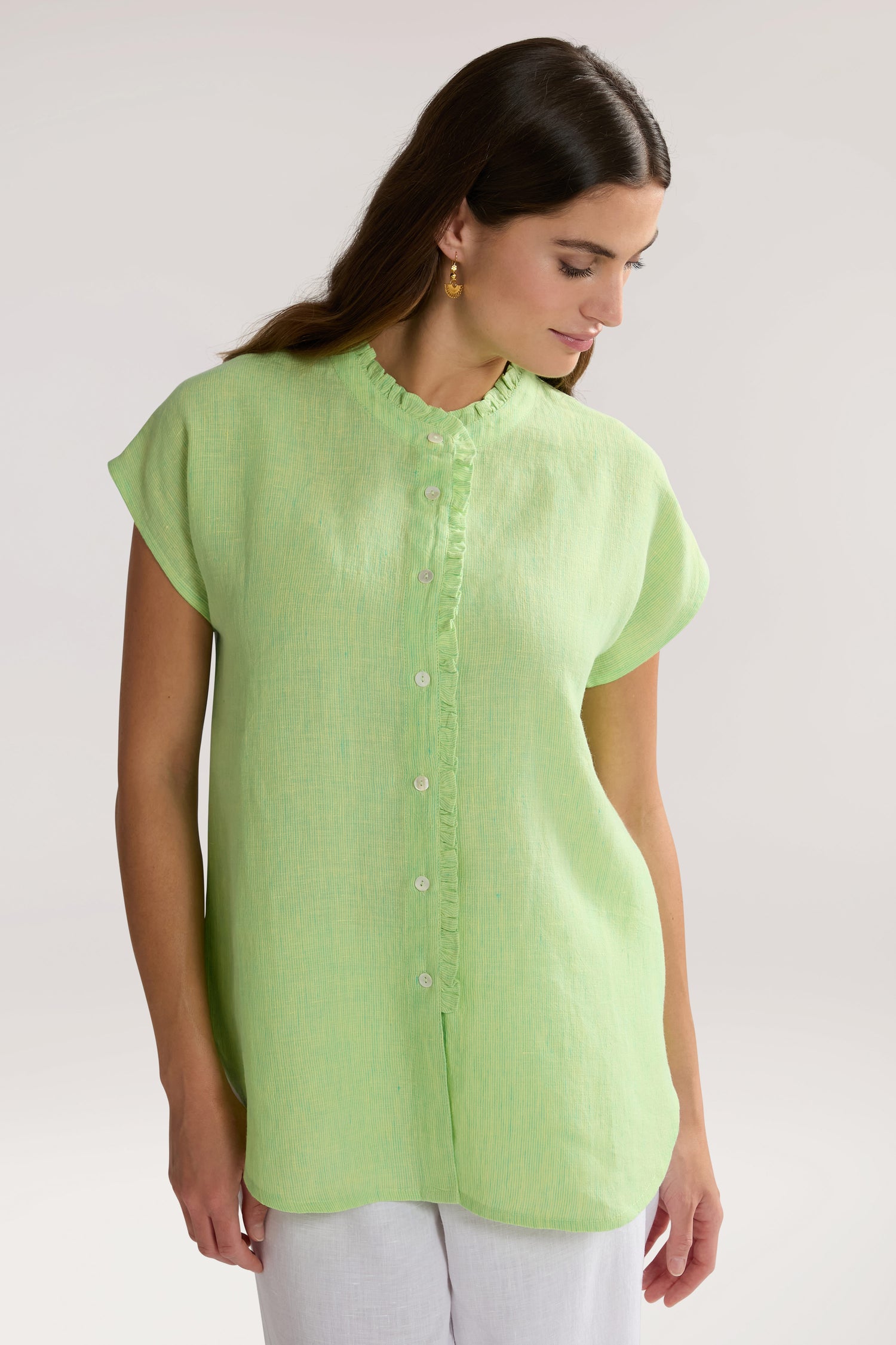 A woman in a green Linen Ticking Stripe Ruffle Front Shirt.