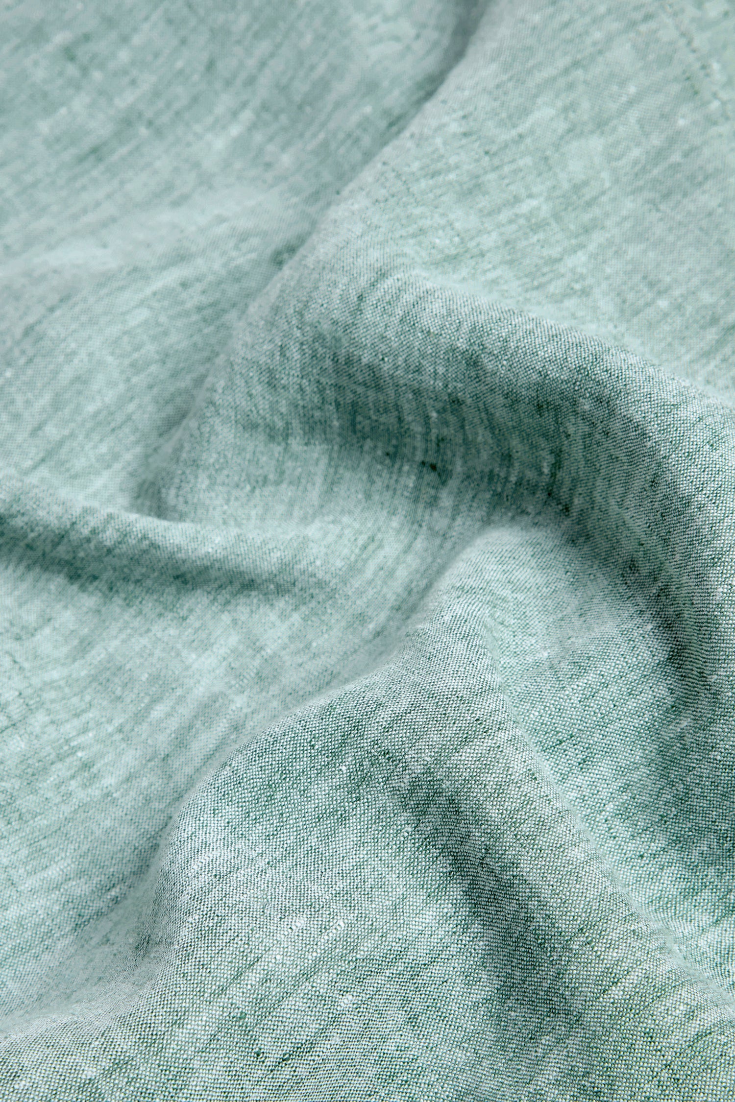Close-up of the Crinkle Linen Cross Dye Shirt in light green, showing the textured weave and natural folds of its linen fabric.
