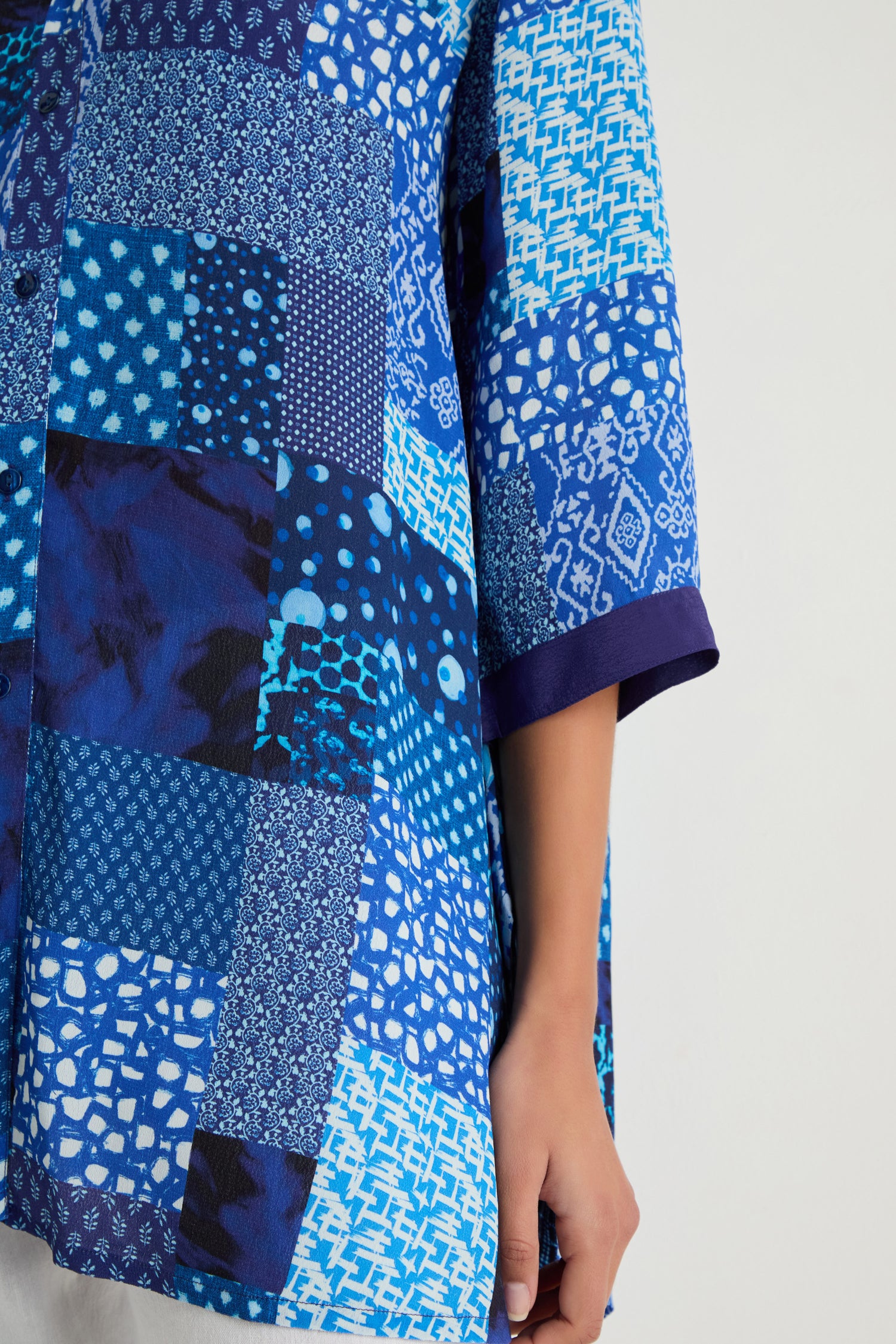 Only an arm and part of the Sahara Indigo Patchwork Longline Shirt—featuring geometric and abstract designs on soft viscose crepe—are visible.