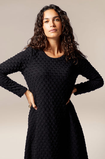 The model is wearing a Pocket Jersey Flared Dress with a long sleeve.