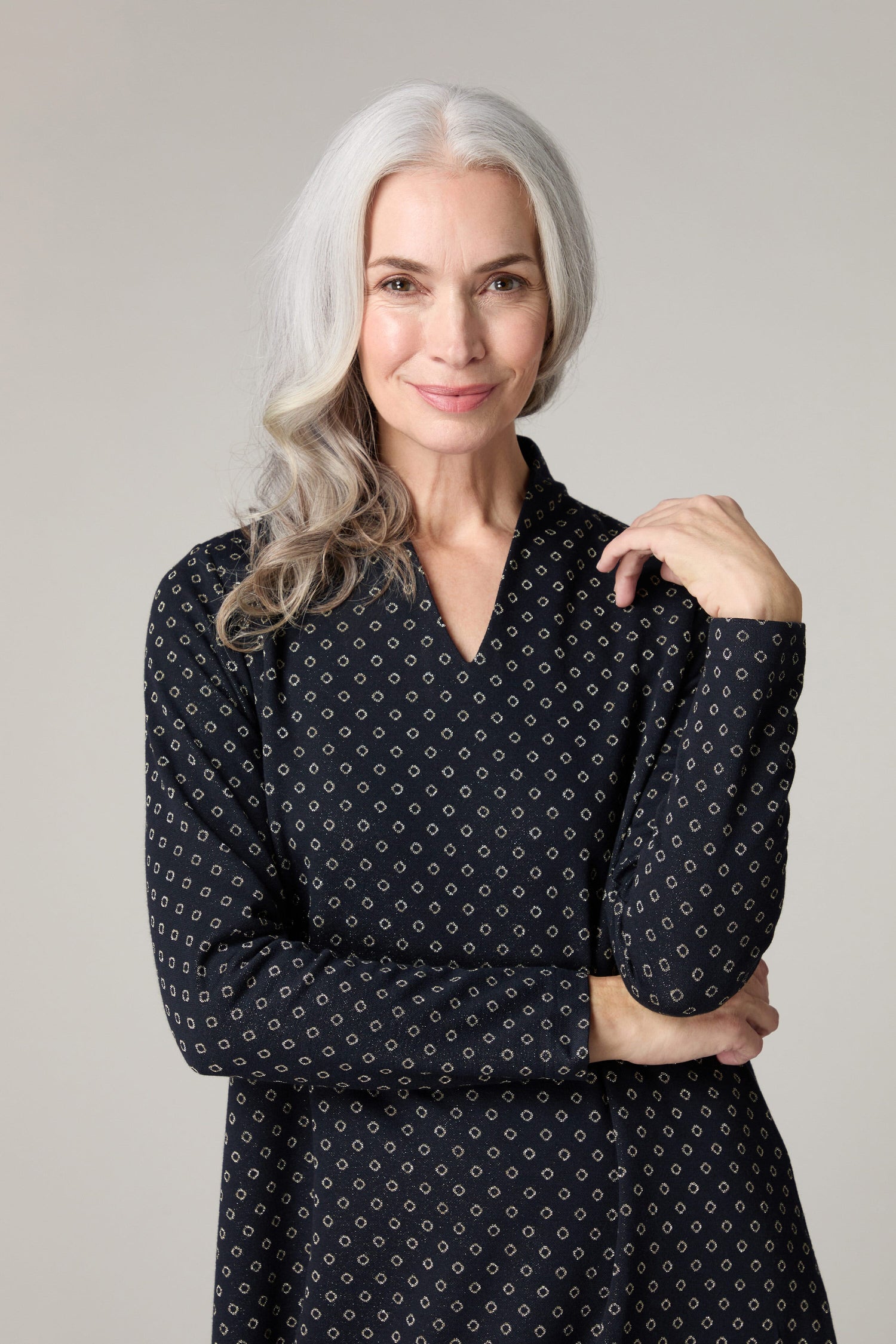 A woman wearing a V-neck black polka dot tunic in Lurex Spot Jersey Dress.