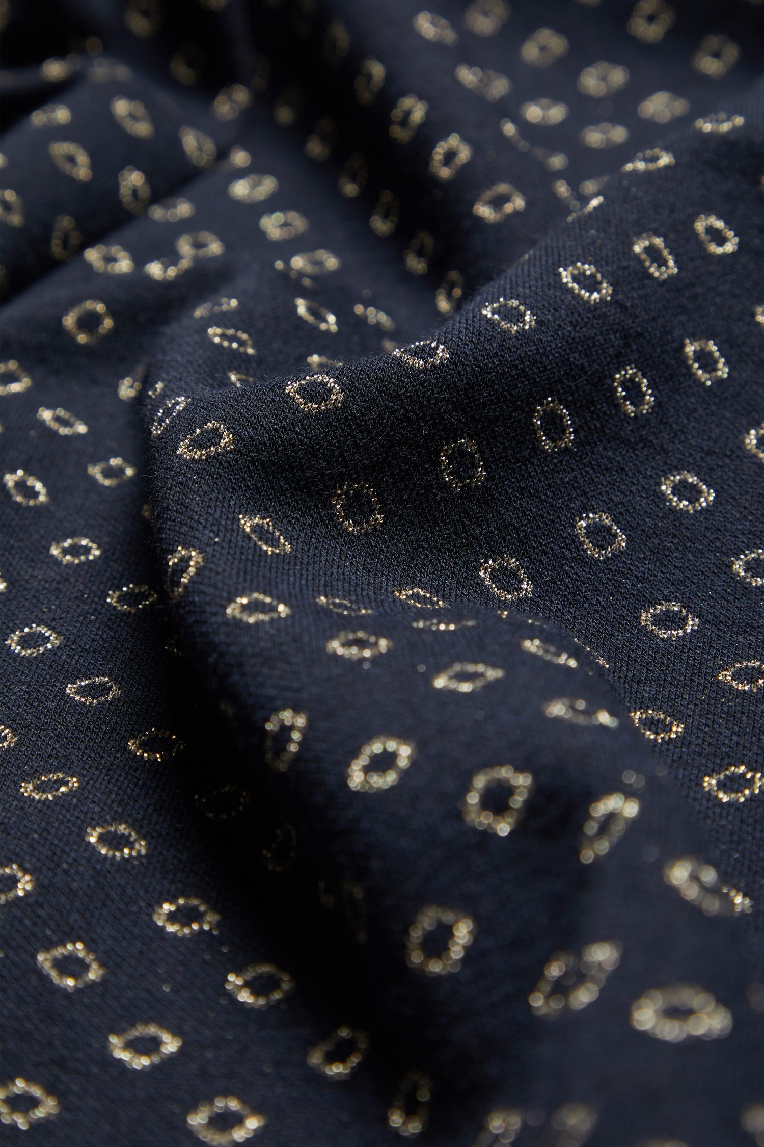 A close up of a Lurex Spot Jersey Dress fabric.