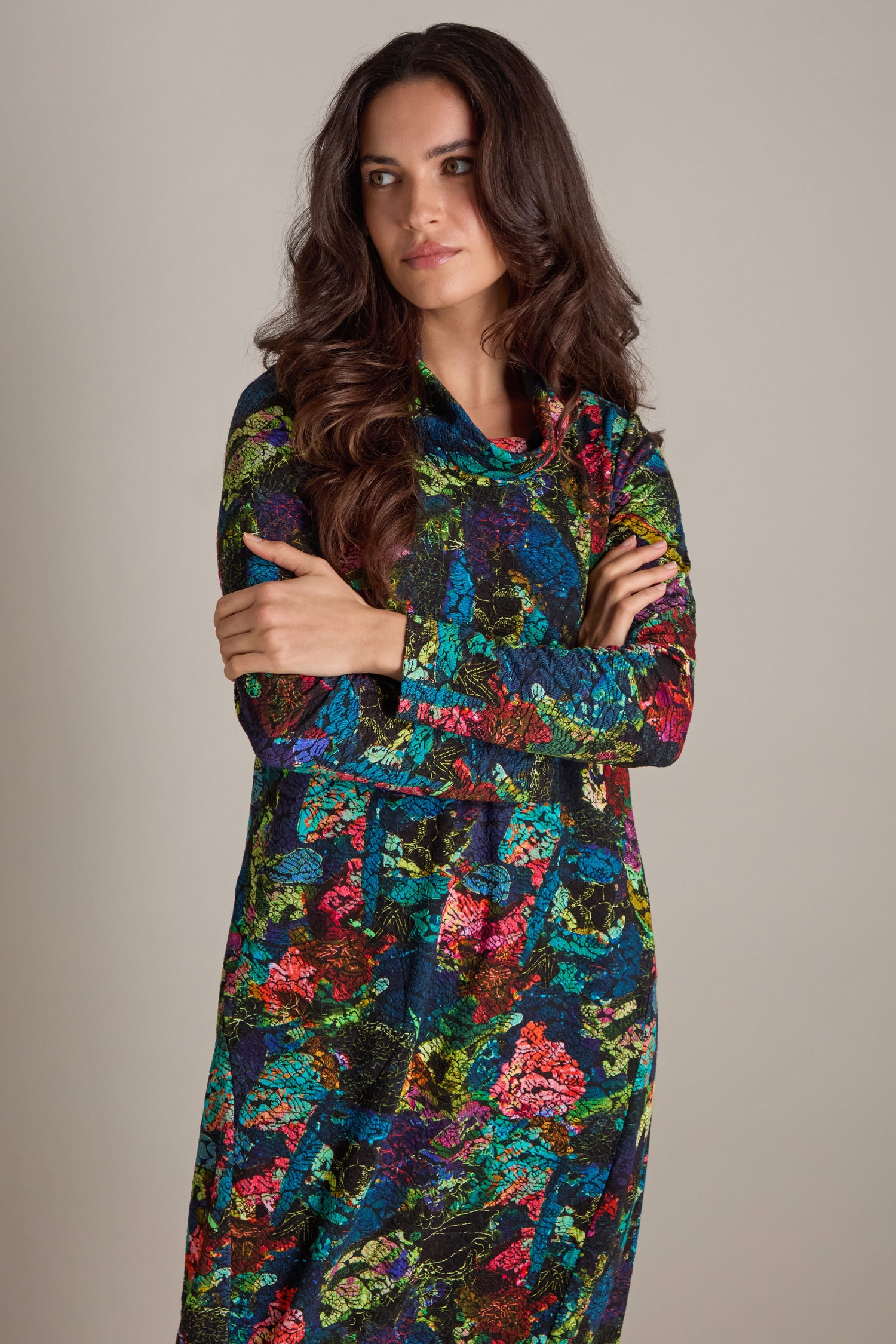 A woman with long dark hair, wearing the Abstract Floral Jersey Bubble Dress, stands with her arms crossed against a neutral background.