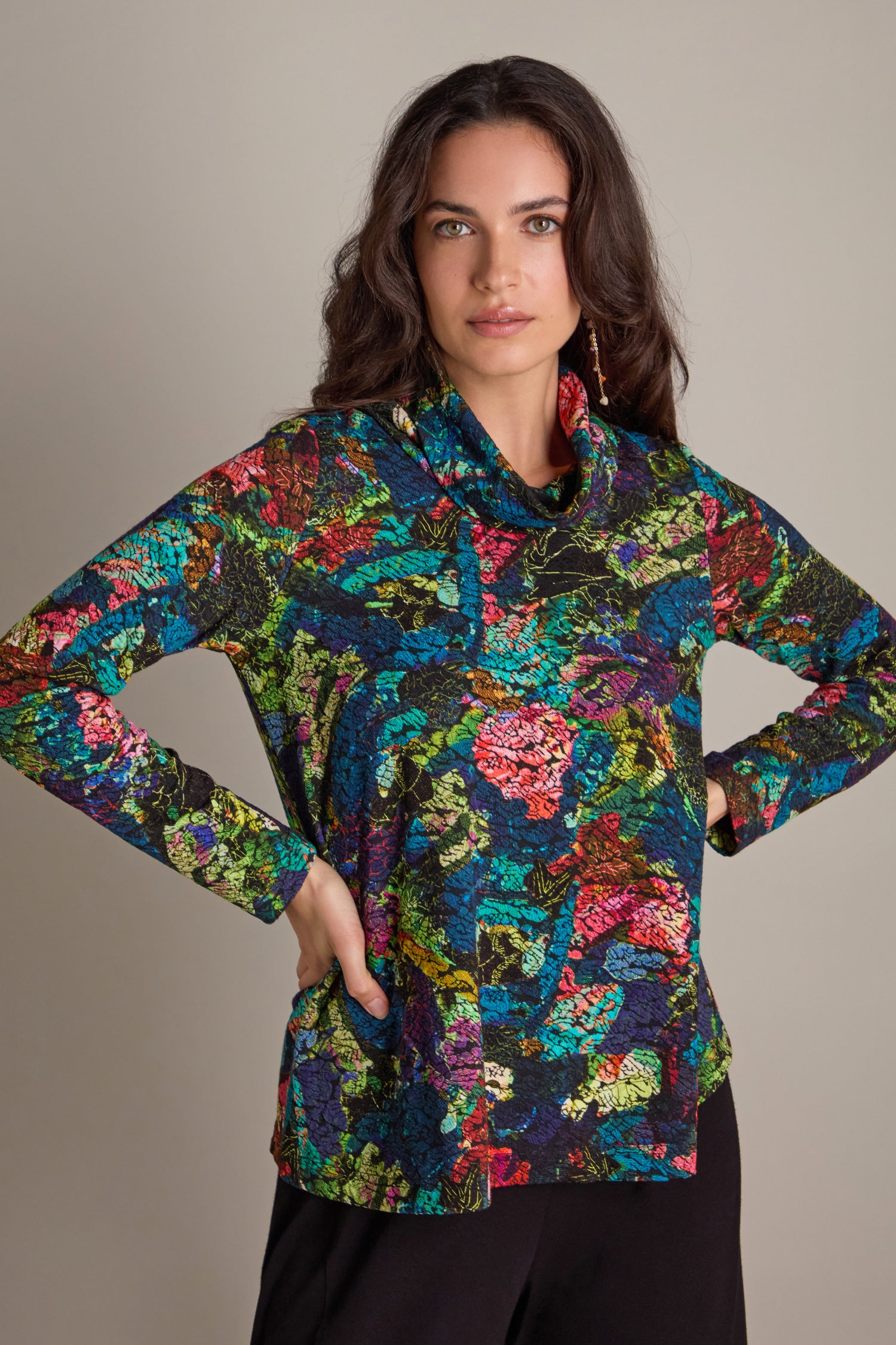 A person wearing the Abstract Floral Jersey Cowl Neck Top paired with black pants stands against a neutral background.