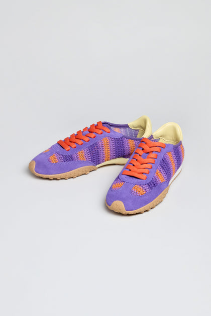 Bridge Woven Purple Crochet Trainers feature orange laces, a cushioned sole, beige outsoles, and light yellow inner lining. Shown against a plain light background.