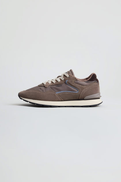 Side view of the City Trainers in brown premium suede, featuring white laces, a white midsole, and a black outsole, displayed against a plain light background.