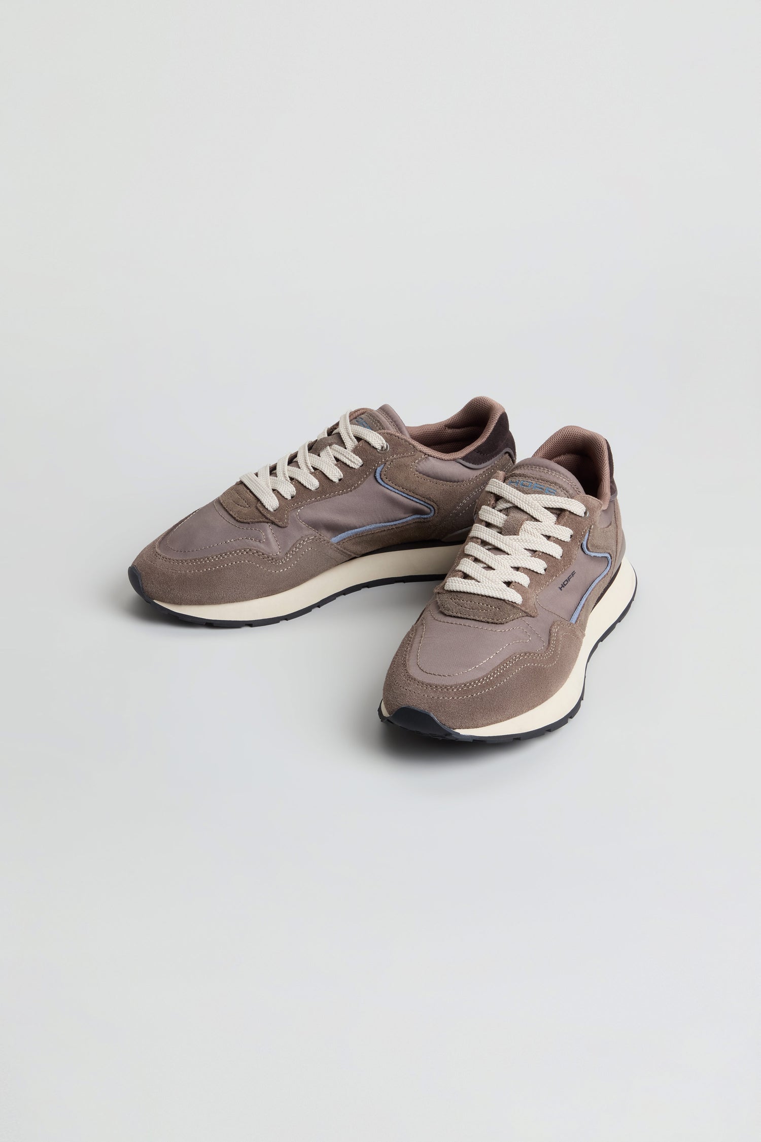 A pair of City Trainers in taupe featuring white soles and laces, displayed on a plain light gray background.