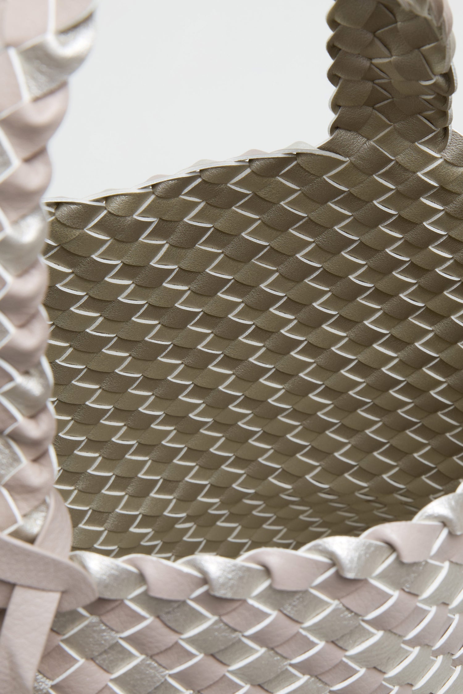 Close-up of the Woven Reversible Grey & Silver Bag, featuring a basket weave pattern with metallic and matte strips in light beige and silver, highlighting its detailed texture and expert craftsmanship.
