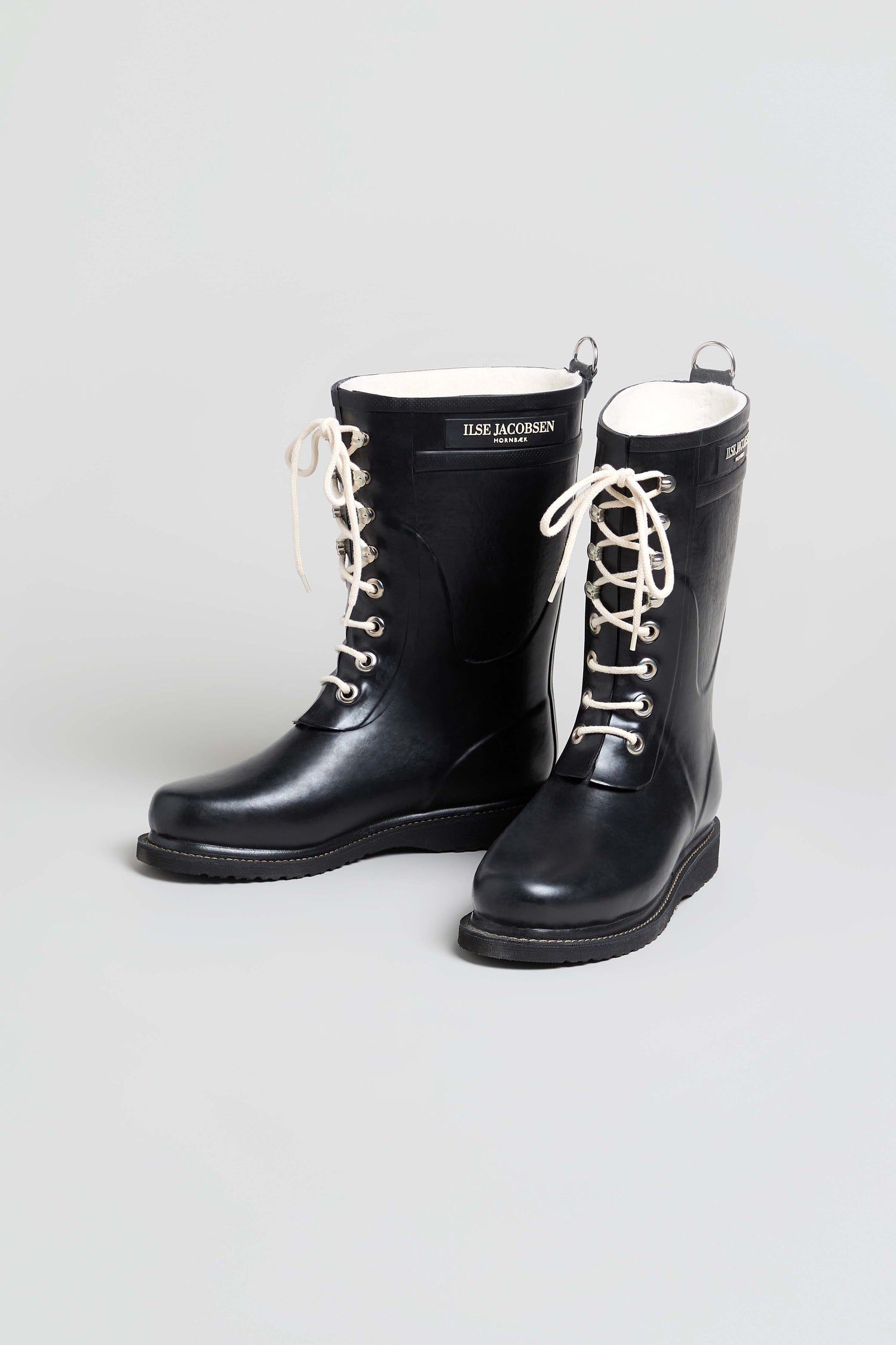Pair of black Lace Up Wellington Boots, made from natural rubber with white soles and white laces, displayed on a plain light gray background—ideal wet-weather footwear for any rainy day.