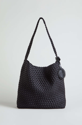 The Black Braided Shoulder Bag is shown upright against a plain light background, showcasing its woven construction, single strap, and round leather tag.