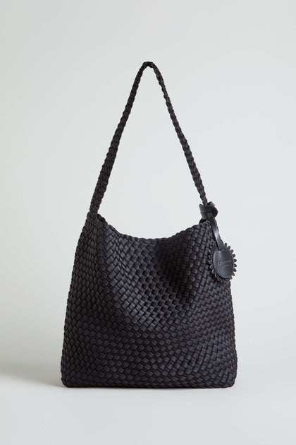The Black Braided Shoulder Bag is shown upright against a plain light background, showcasing its woven construction, single strap, and round leather tag.
