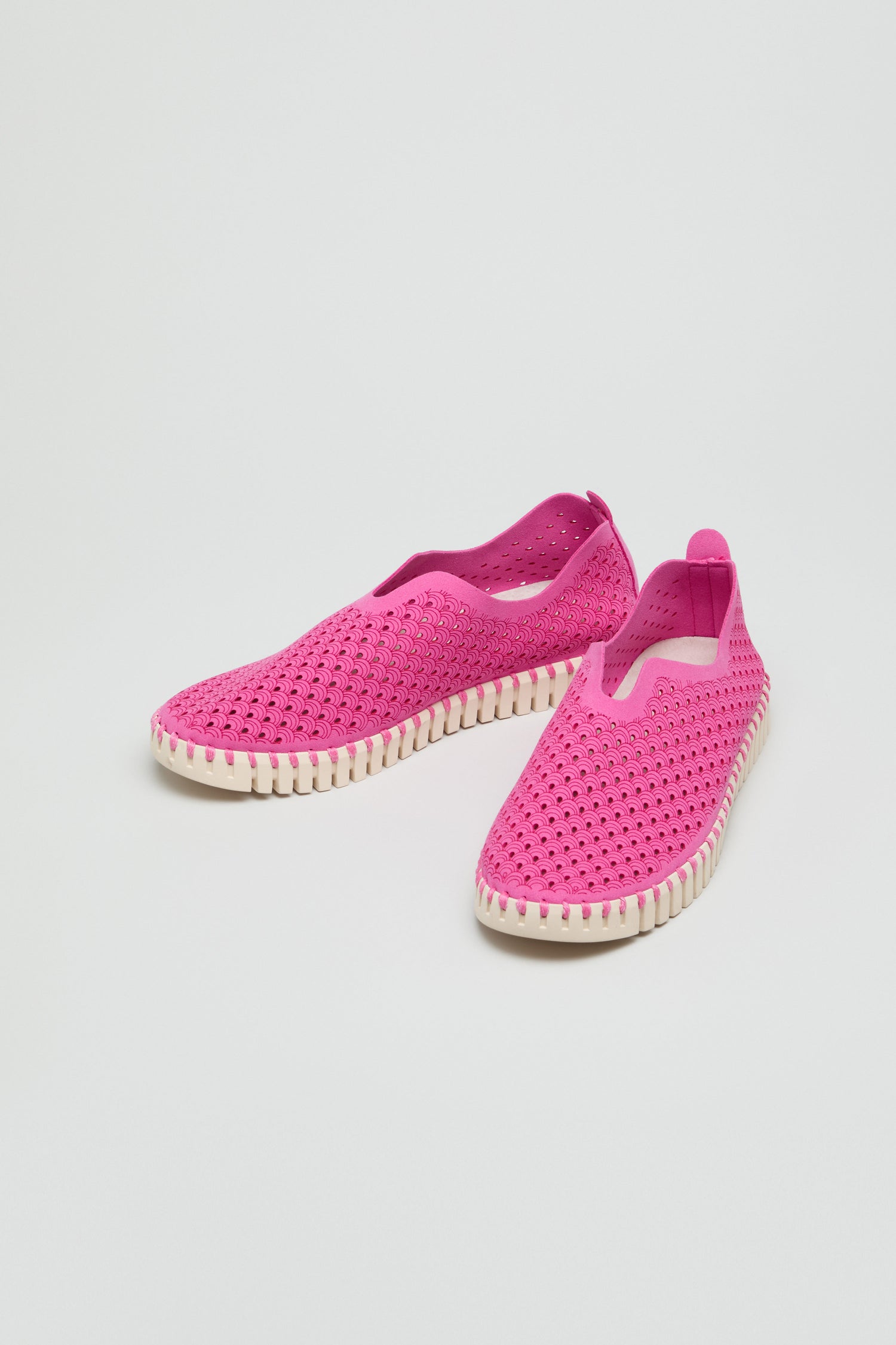 A pair of Rose Tulip Slip on Shoes featuring bright pink perforated uppers and white ridged soles for lightweight comfort, displayed on a plain white background.