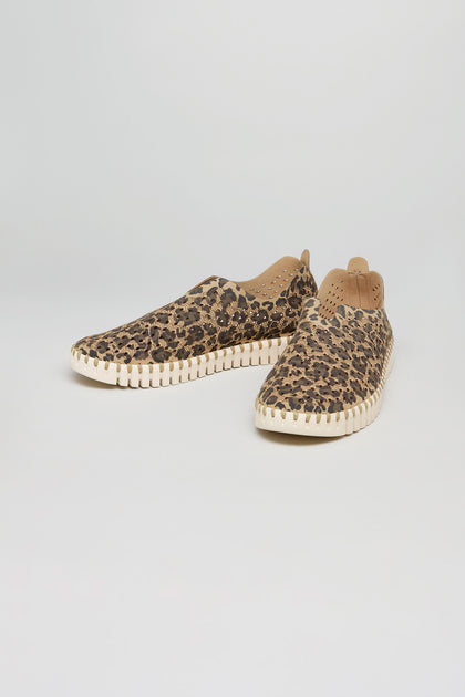The Tulip Leopard Slip On Shoes feature brown and black leopard print uppers with a tan sole, displayed on a plain white background—ideal for anyone seeking stylish, sustainable casual footwear.
