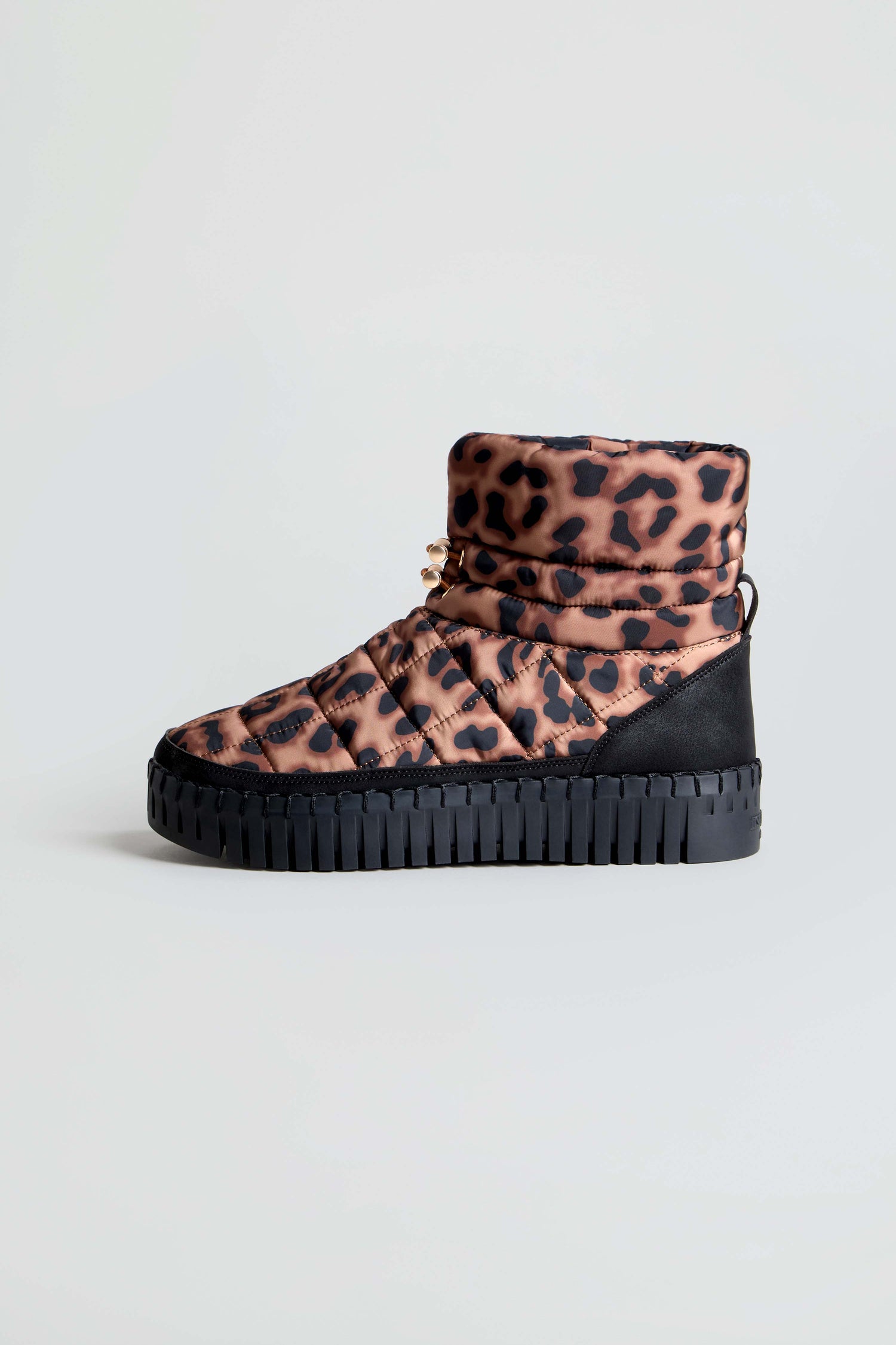 The Tulip Quilted Panther Winter Boot, featuring a water-repellent quilted exterior in a bold leopard print, a black heel, and a cushioned platform sole, is displayed against a plain light background.