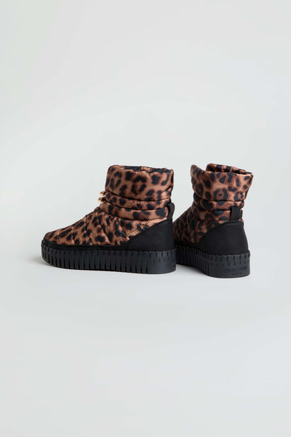 Two pairs of Tulip Quilted Panther Winter Boots, featuring ankle-high design, thick cushioned platform soles, and a bold panther print pattern on the quilted upper fabric, displayed against a plain light background.